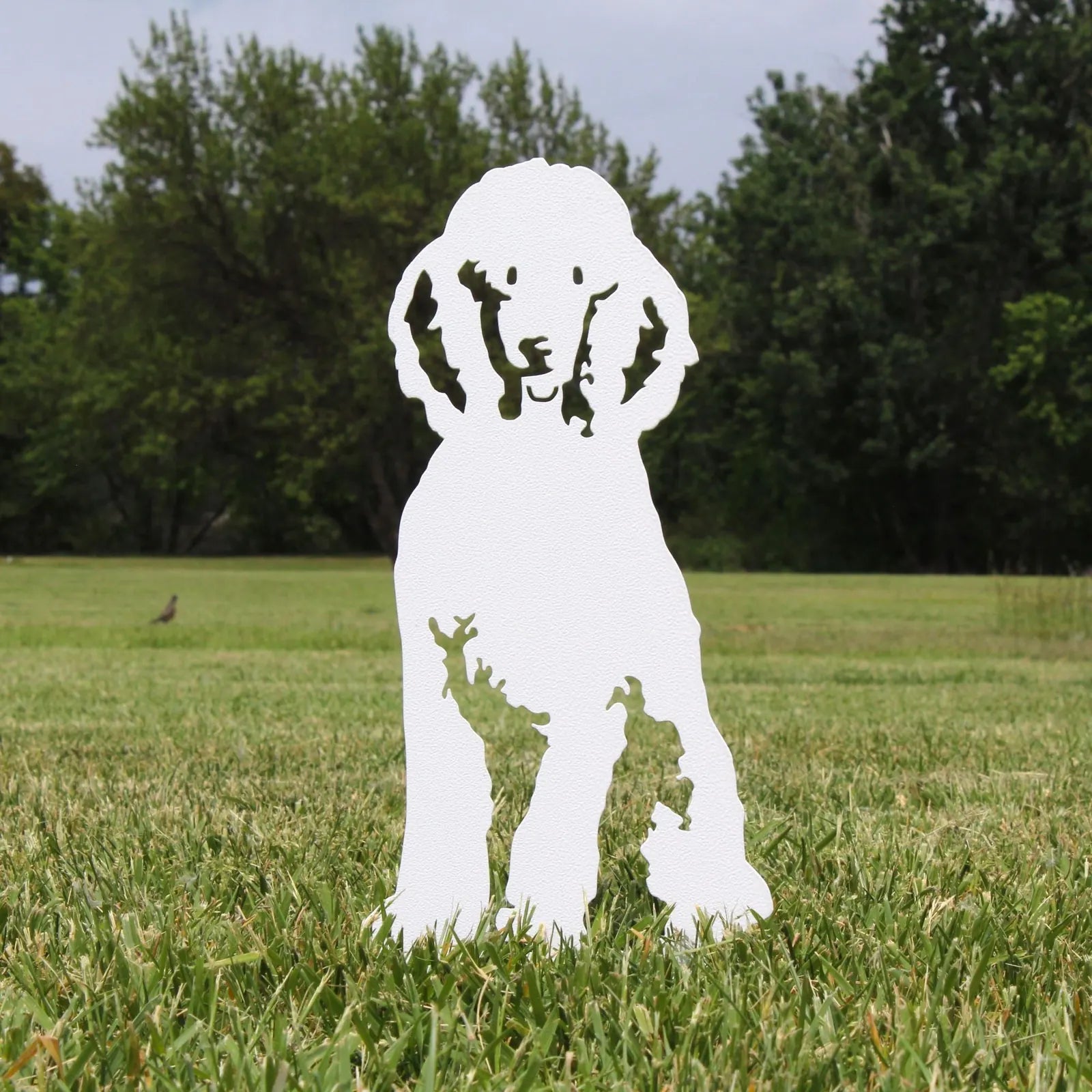 Handcrafted white metal silhouette of a poodle, perfect for outdoor garden decor, highlighting intricate details.