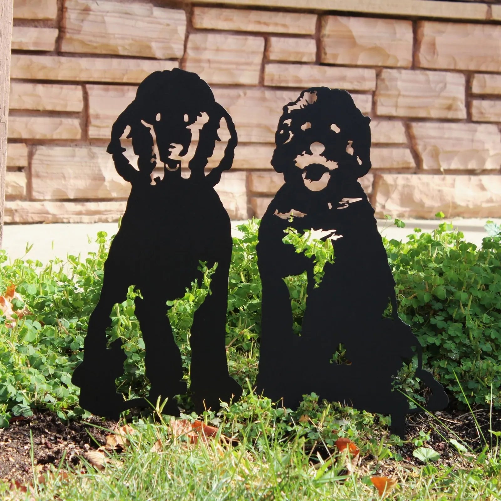 Black metal dog silhouettes stand among greenery, capturing the essence of outdoor decor for dog lovers.