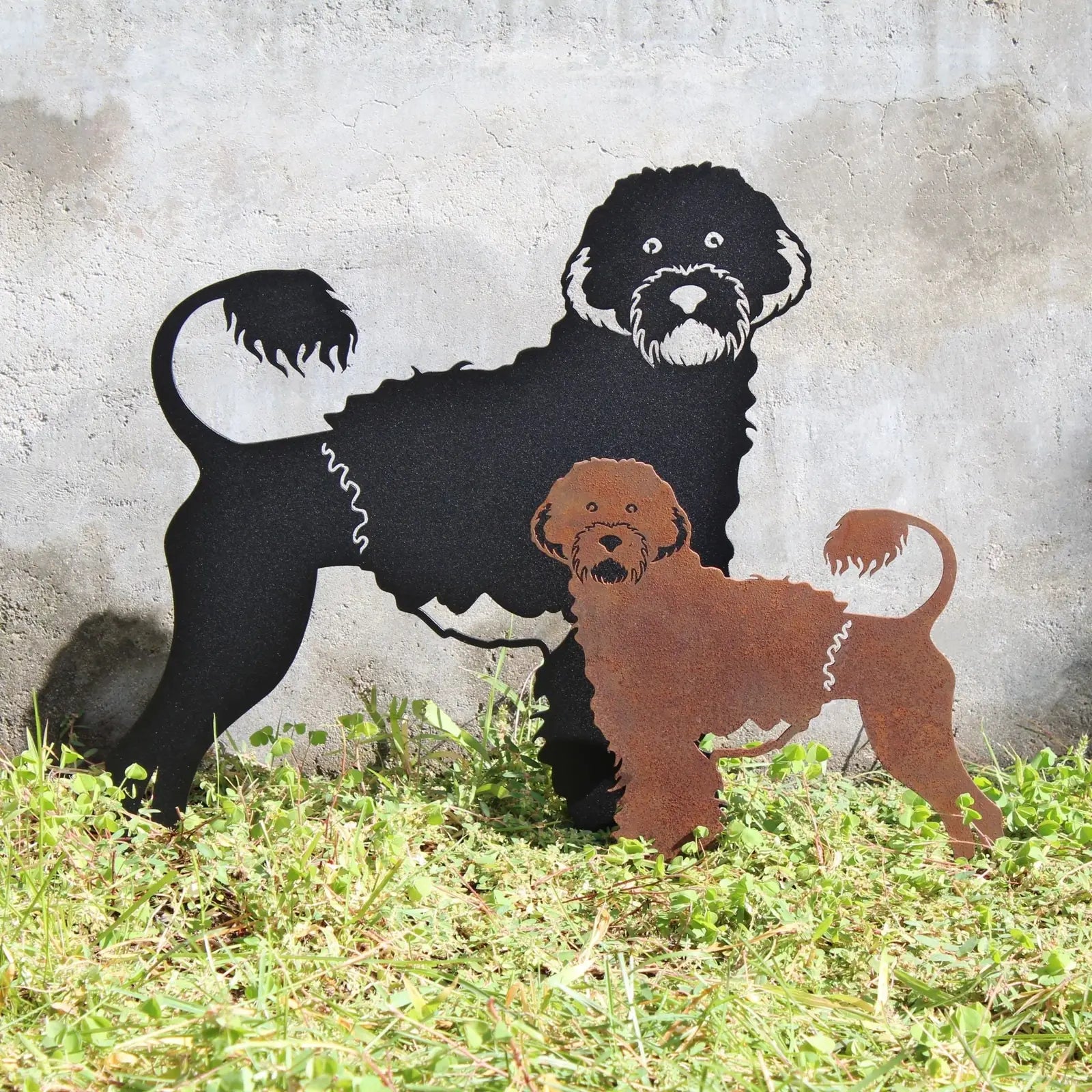 Portuguese Water Dog metal silhouette in black and rust finishes, displayed on grass against a textured wall.