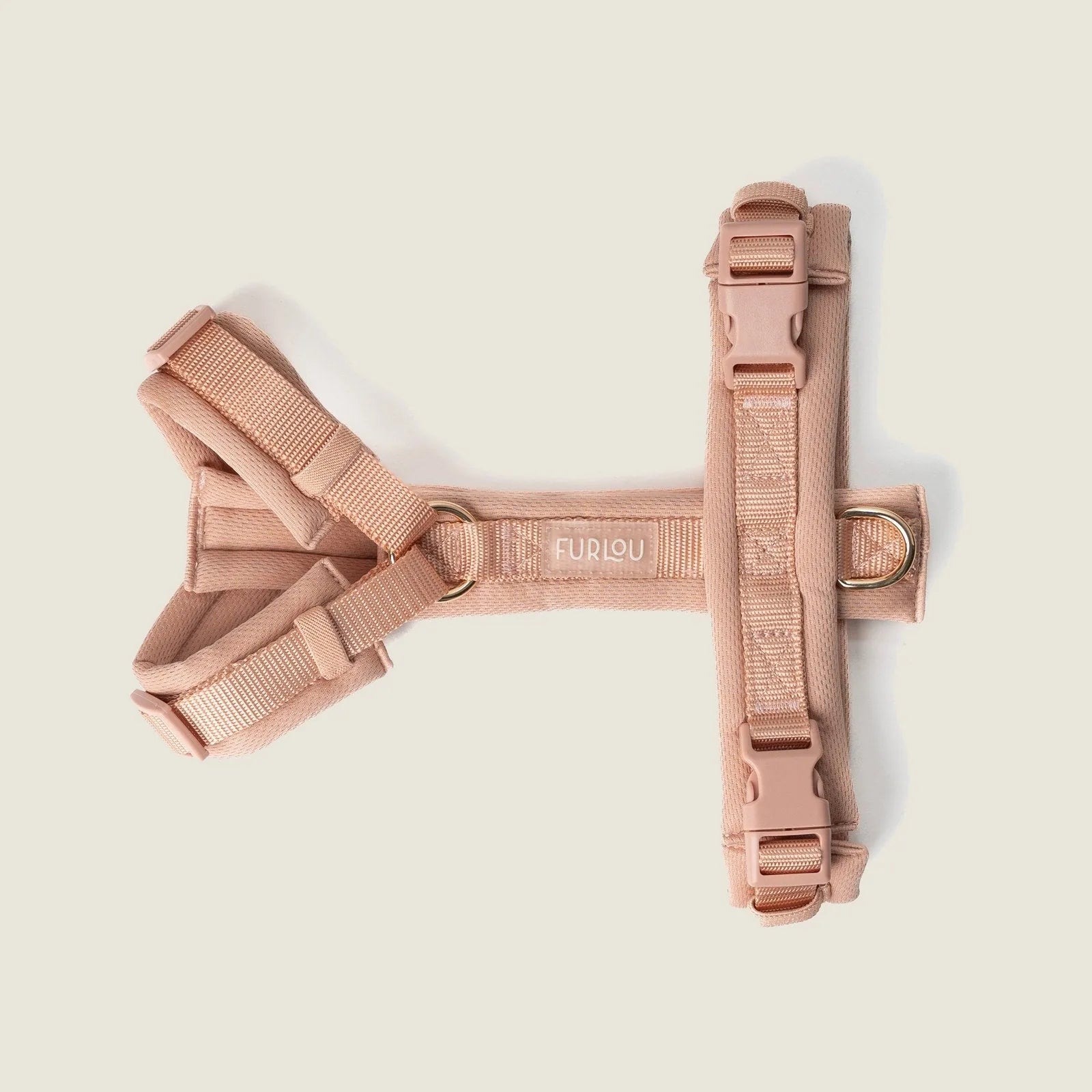 Powder rose comfort dog harness by FURLOU with adjustable straps and gold hardware, designed for a secure fit.
