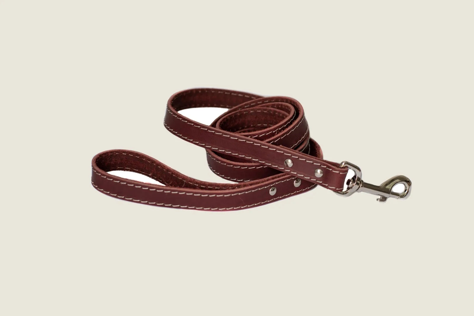 Chocolate brown leather dog leash featuring white stitching and a metal clip, ideal for stylish walks.
