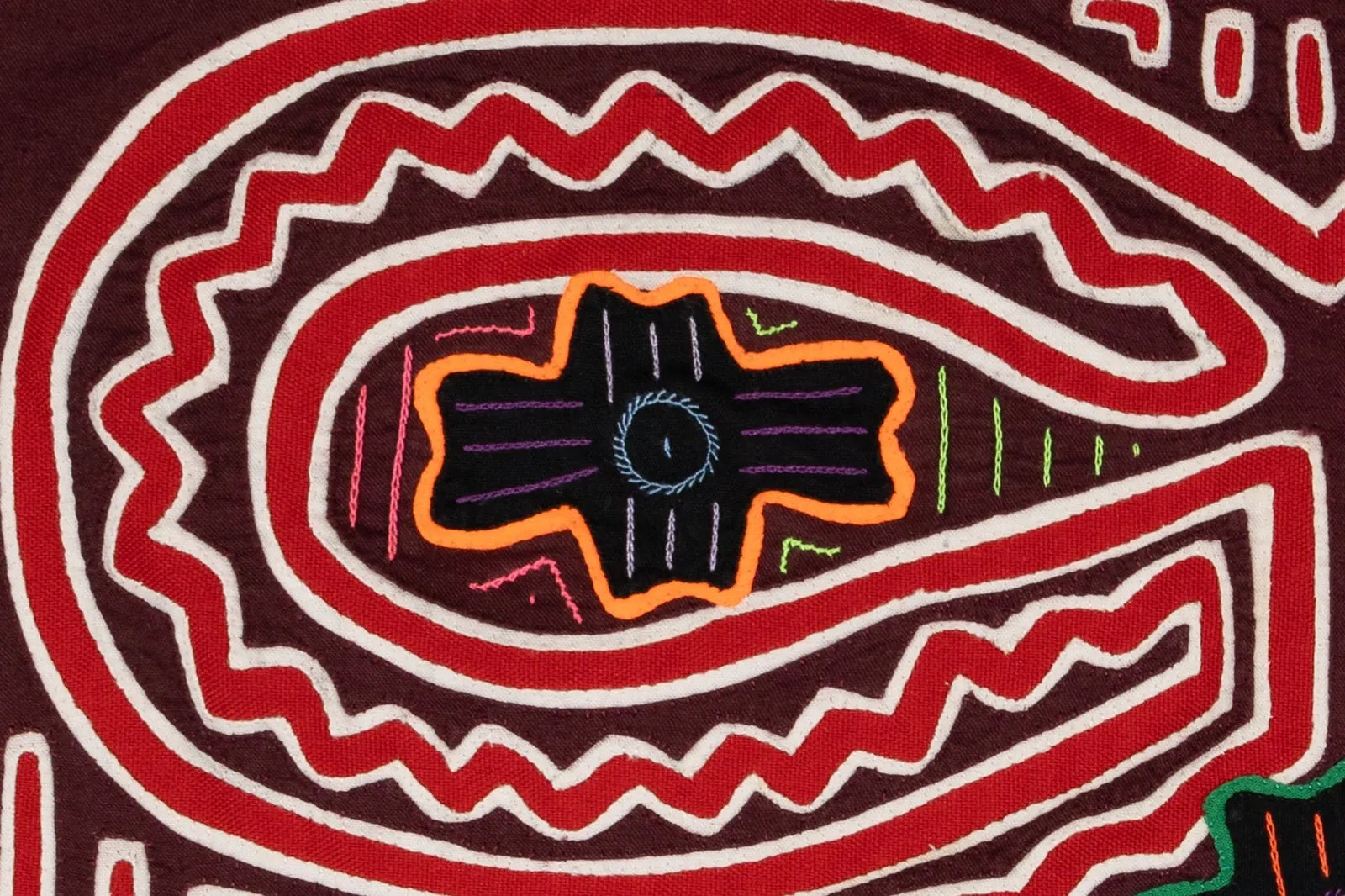 Colorful Mola textile featuring intricate geometric patterns in red, black, and orange, showcasing hand-stitched craftsman...