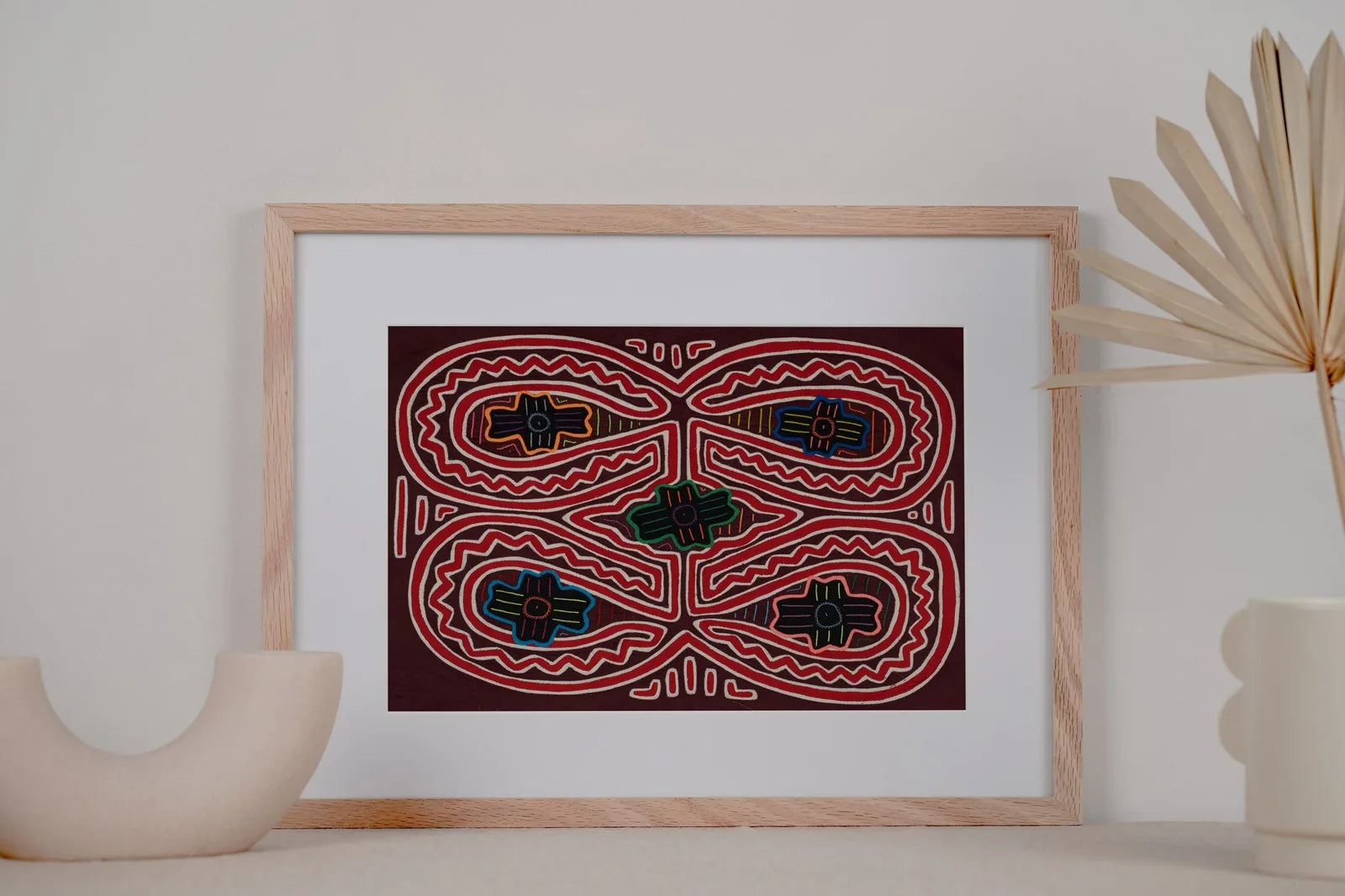 Hand-stitched Panama Mola textile art featuring vibrant geometric patterns in red, blue, and green on a dark background.