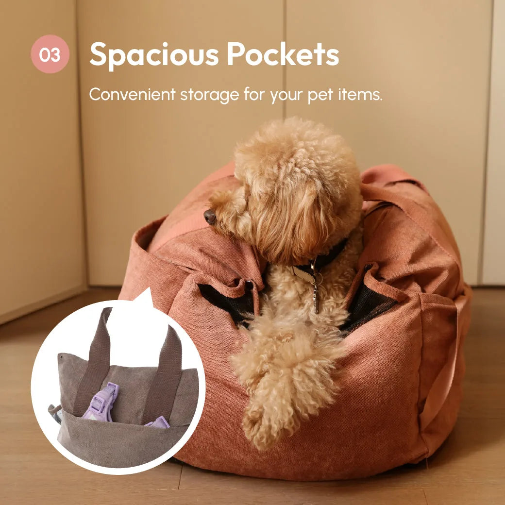 Soft pink pet car seat with spacious pockets and a small dog comfortably resting inside.