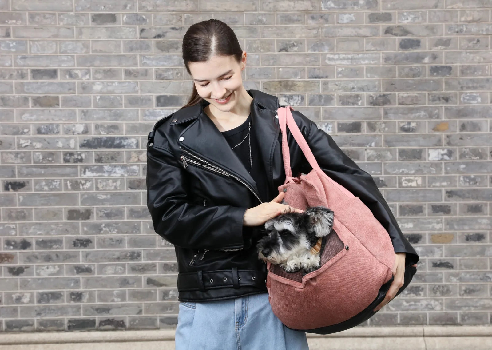 Pink Puff Guard Dog Car Seat held by a woman in a black leather jacket, with a small dog comfortably inside.