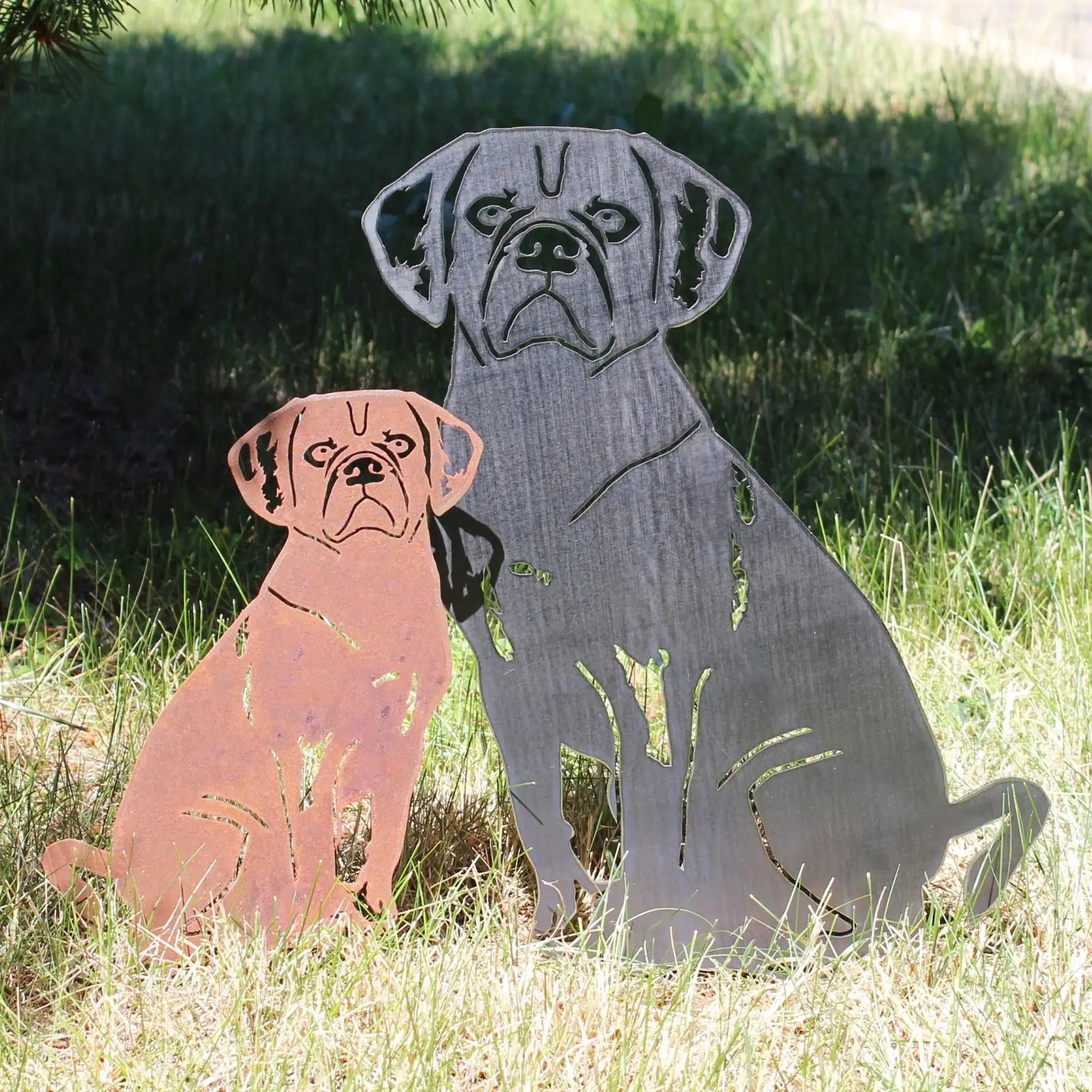Puggle metal silhouettes in Corten steel and matte black, showcasing detailed cutouts, displayed on grass.