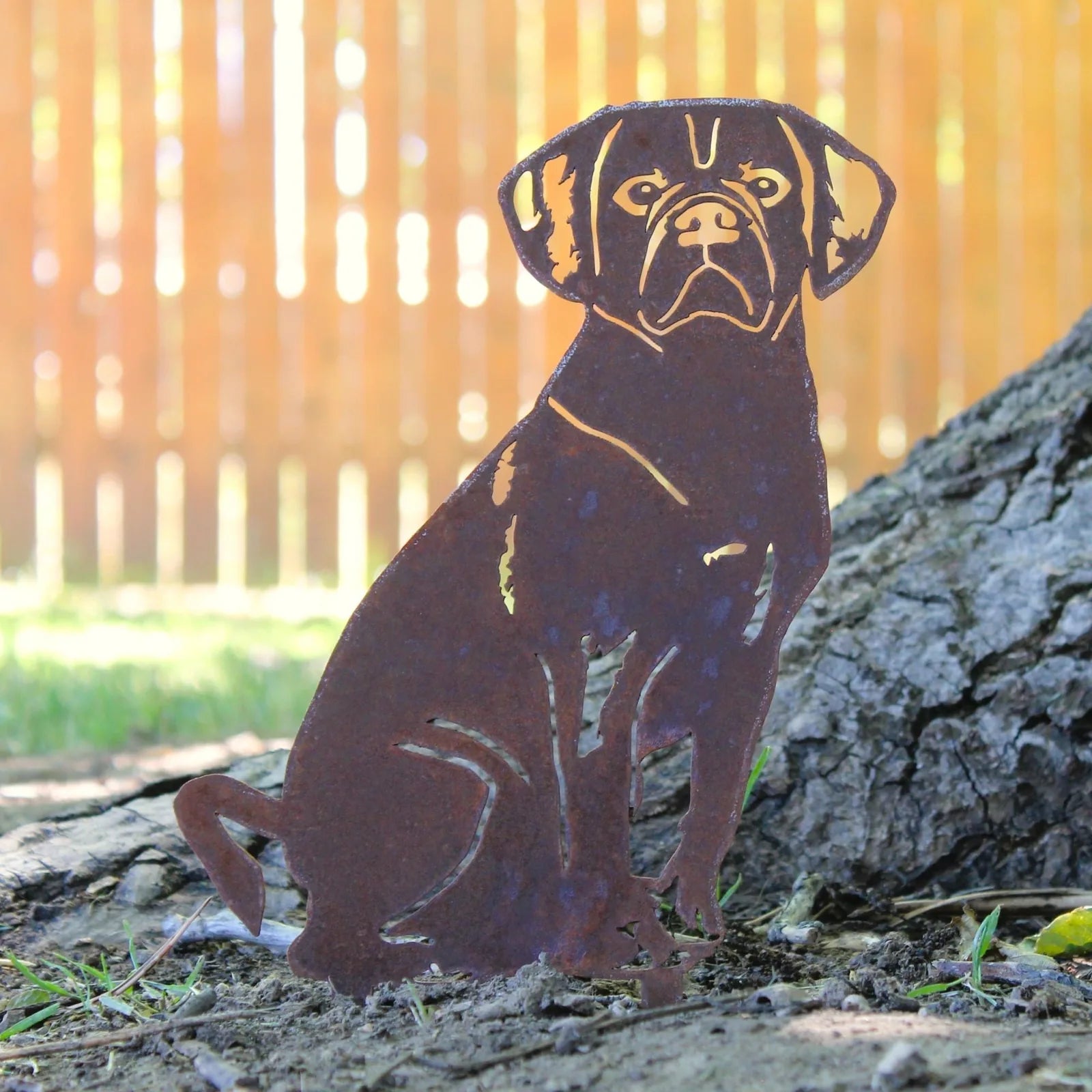 Handmade Corten steel Puggle silhouette with a rustic finish, set against a natural outdoor background.