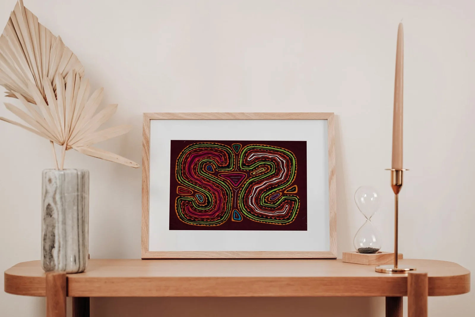 Vibrant hand-stitched Mola tapestry featuring a puppy dog face design in bright colors on a dark background.