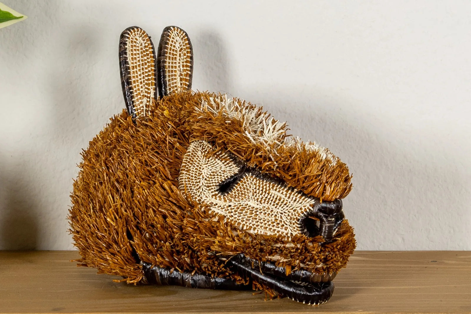Handwoven brown puppy dog mask featuring intricate textures and patterns, crafted from natural materials.
