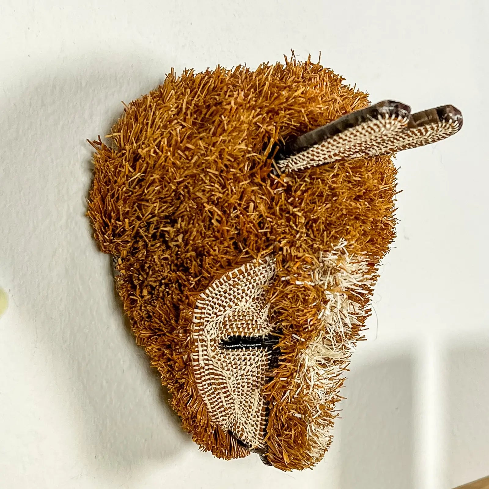 Handwoven puppy dog mask in shades of brown, featuring natural fibers and intricate detailing, showcasing traditional craf...