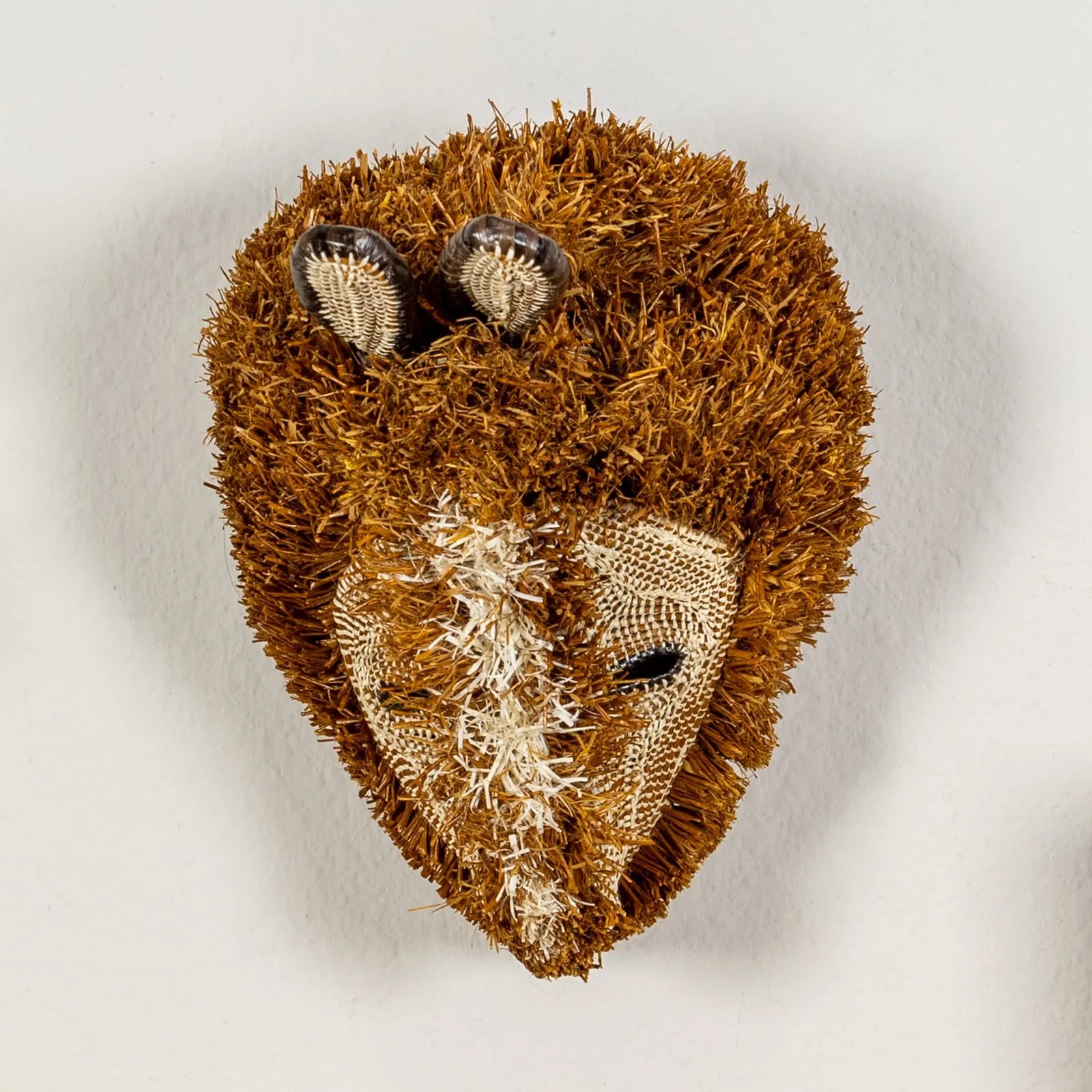 Handwoven brown Puppy Dog Mask features intricate natural designs and textures, showcasing traditional craftsmanship from...
