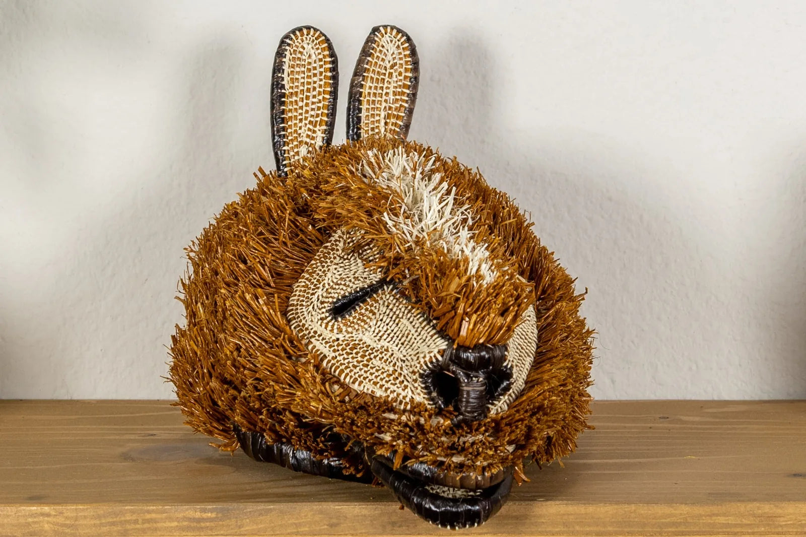 Handwoven brown and tan Puppy Dog Mask with detailed textures, crafted from natural materials by Indigenous artisans.