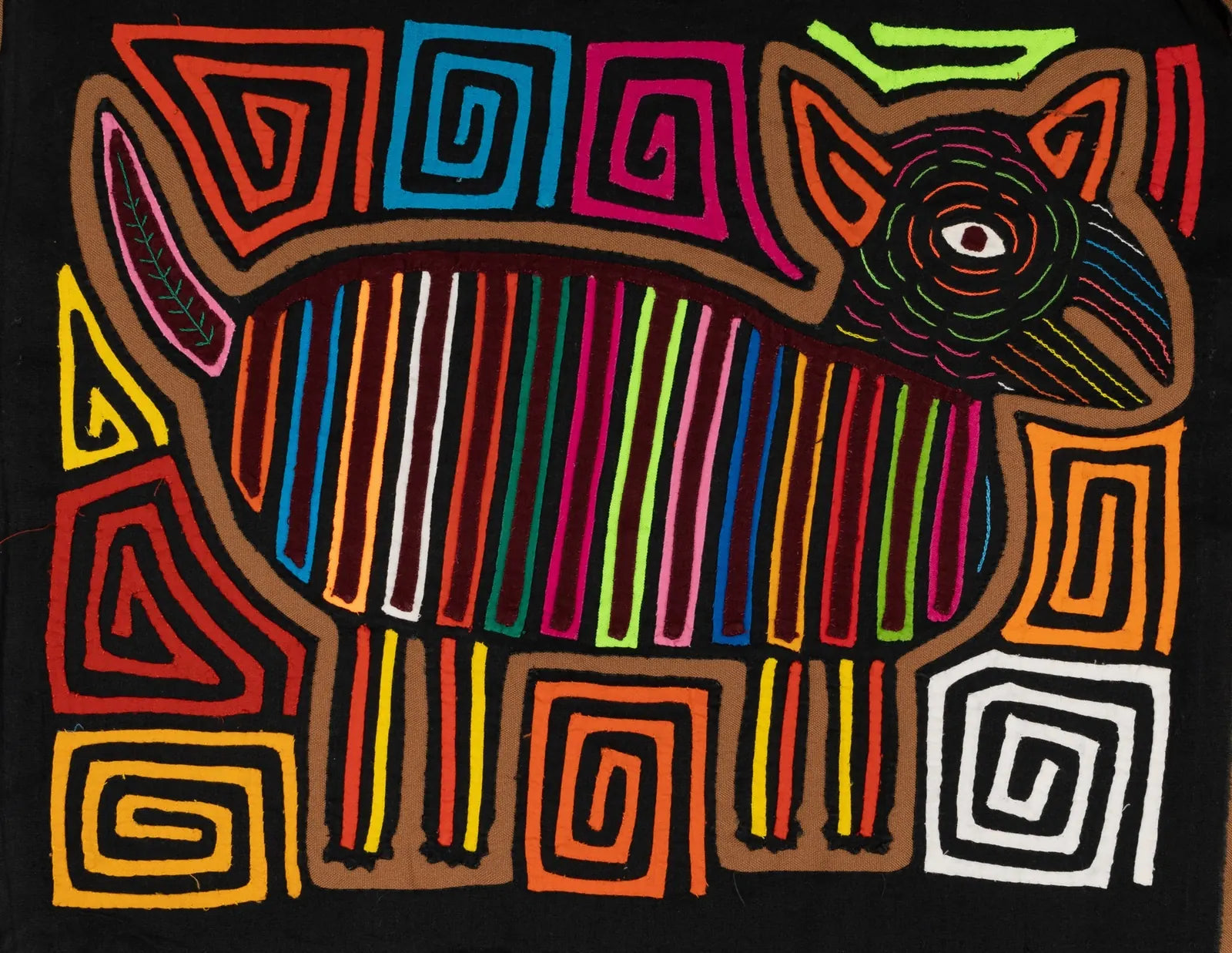 Colorful hand-stitched Mola featuring a stylized dog outline with bold vertical stripes on a black background.