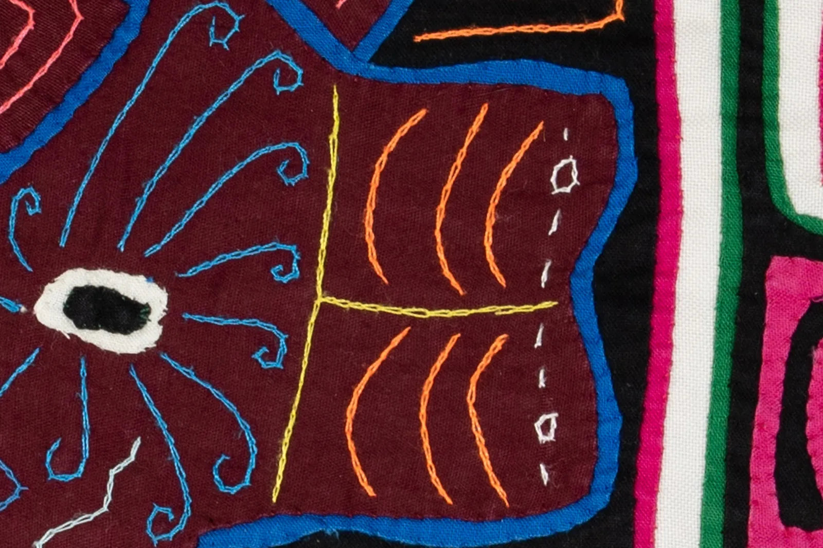 Vibrant hand-stitched Mola featuring geometric patterns in maroon, blue, and yellow, showcasing unique Indigenous craftsma...