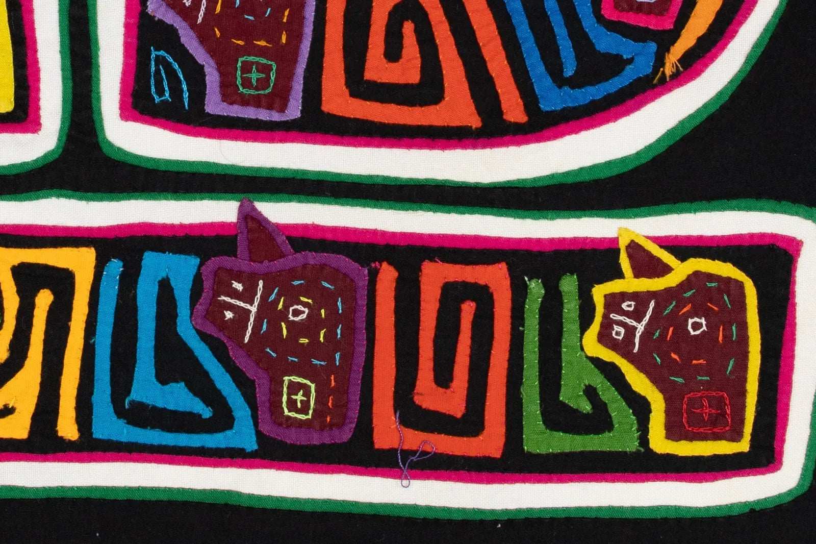 Colorful geometric designs of dogs in vibrant thread, hand-stitched on a black textile Mola by TraderBrock.