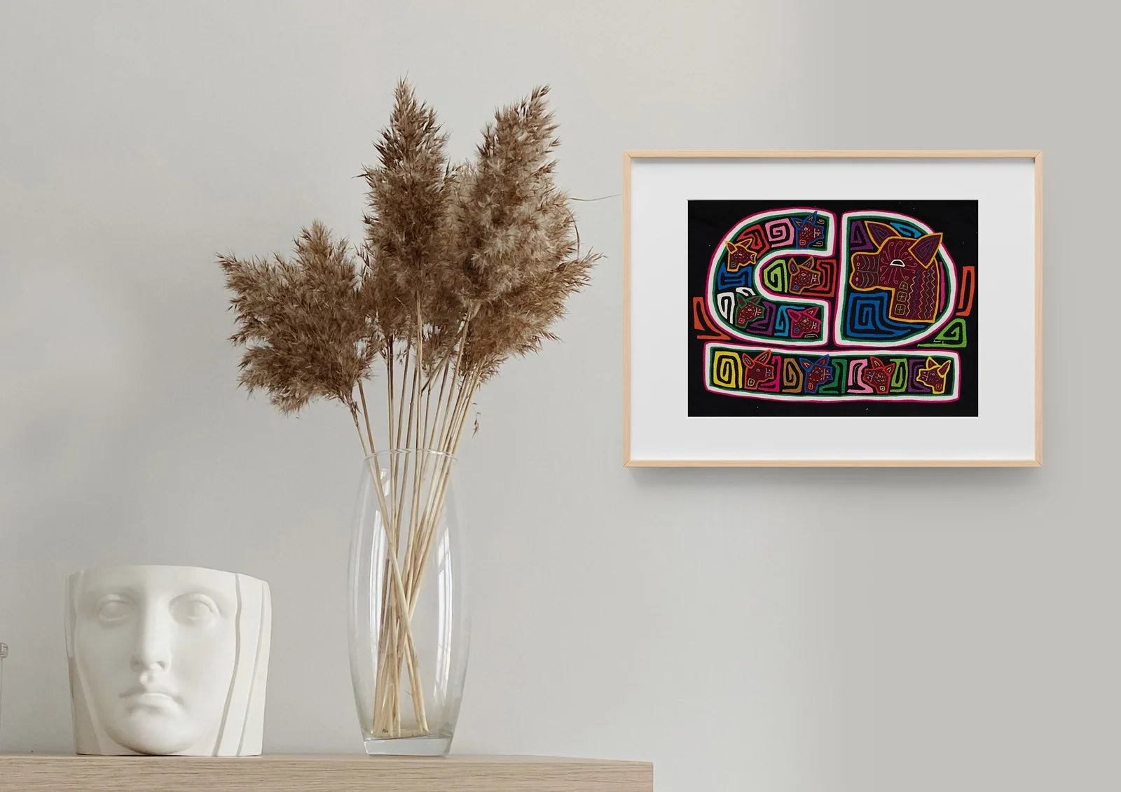 Colorful hand-stitched tapestry featuring geometric patterns and animal motifs against a black background.