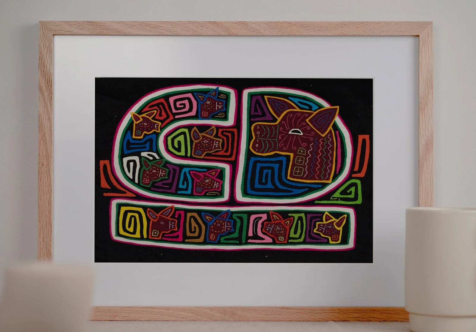 Vibrant hand-stitched Mola tapestry featuring dog motifs and geometric patterns on a black background.