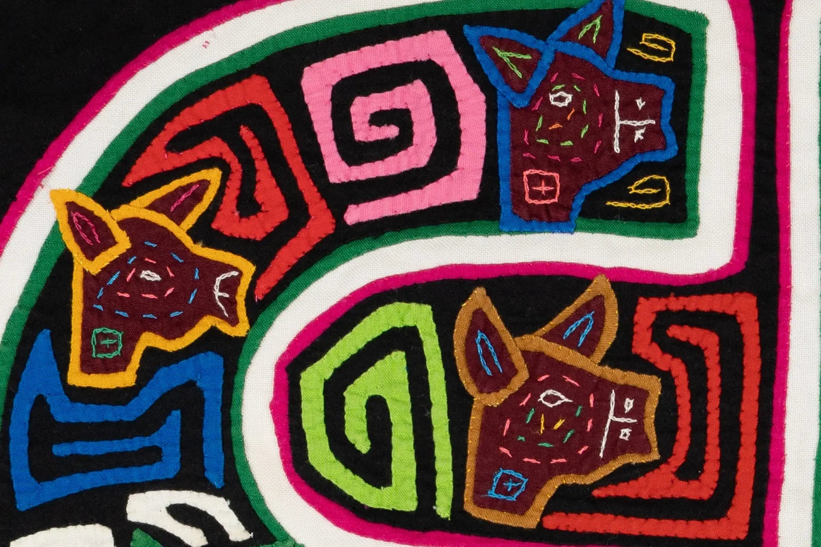 Colorful geometric patterns featuring dog faces, hand-stitched in vibrant threads on a black background.