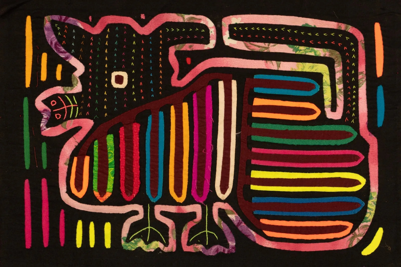 Hand-stitched purple puppy dog tapestry featuring vibrant applique patterns on a black background, showcasing textile art.