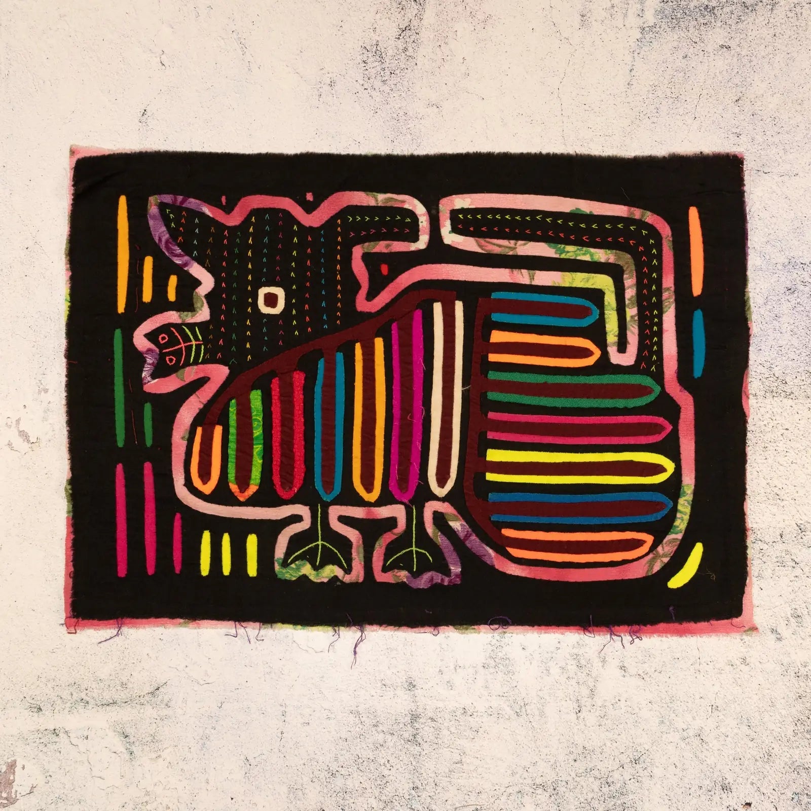 Hand-stitched purple puppy dog tapestry featuring vibrant reverse appliqué patterns on a black background.