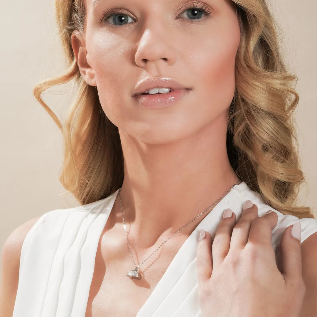 Silver Rainbow Bridge cremation necklace worn on a model, featuring a colorful enamel design and polished chain.