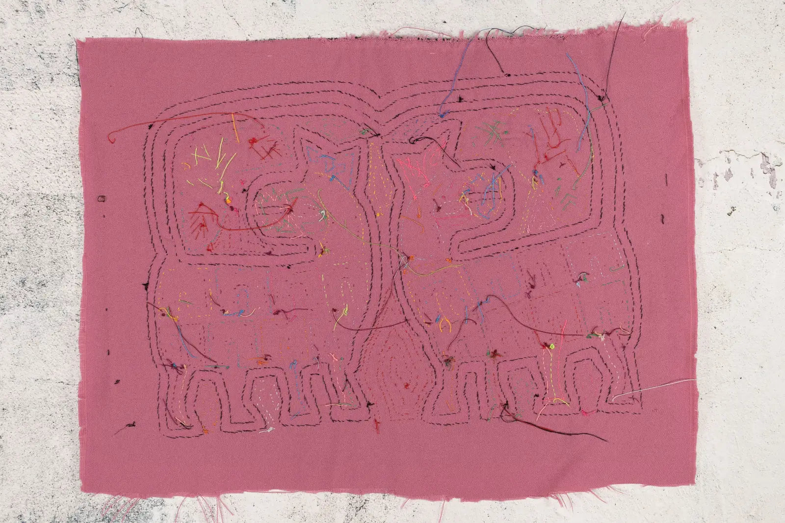 Hand-stitched pink Mola featuring abstract dog designs with colorful thread accents, showcasing traditional Panama textile...