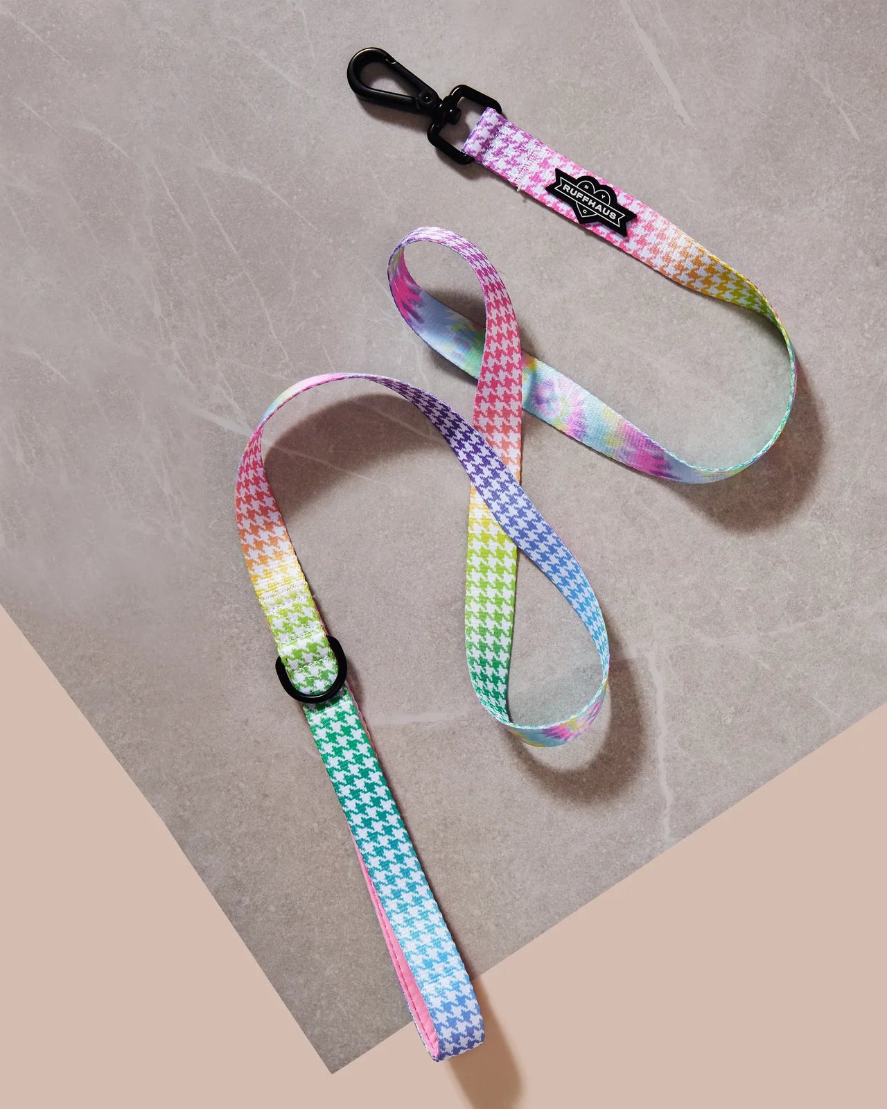 Colorful rainbow houndstooth-pattern dog leash with a neoprene-lined handle and a swivel snap clasp for easy attachment.