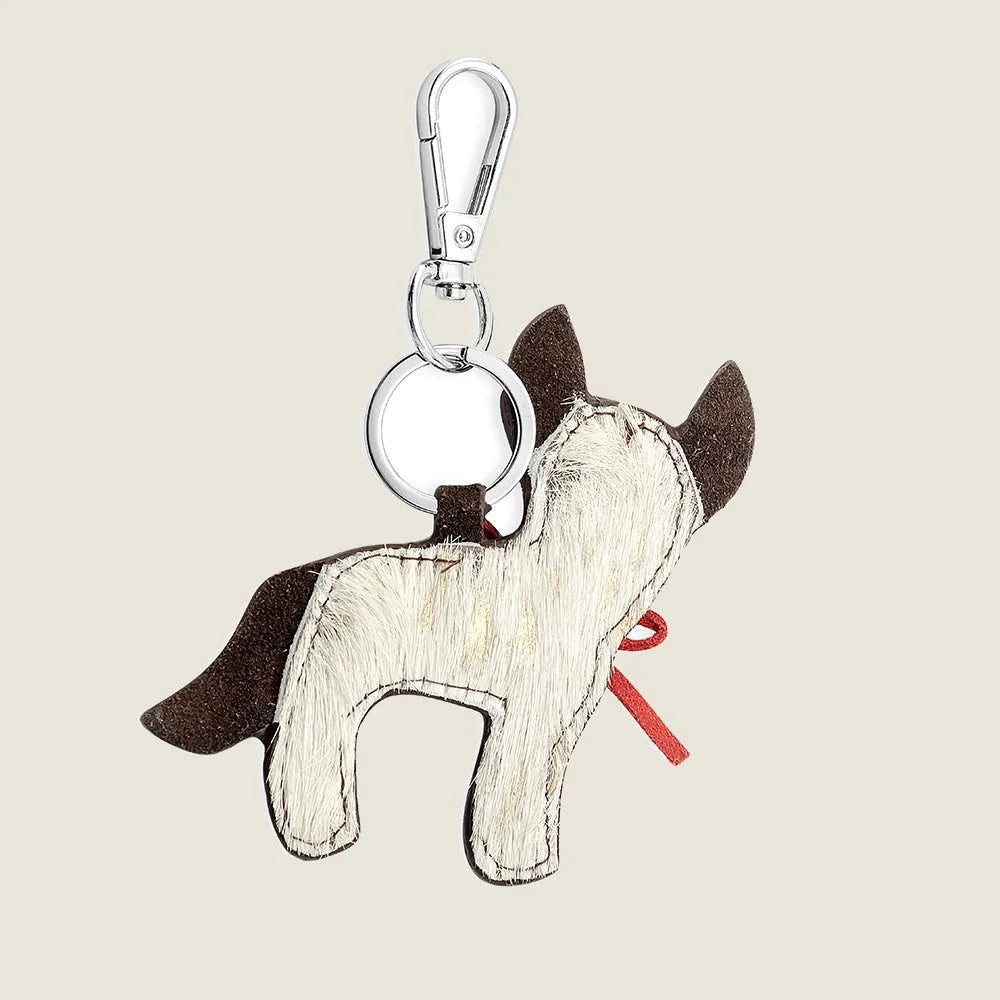 Hair-on-hide cattle dog key fob with a red bow, featuring a whimsical ranch design in brown and white leather.
