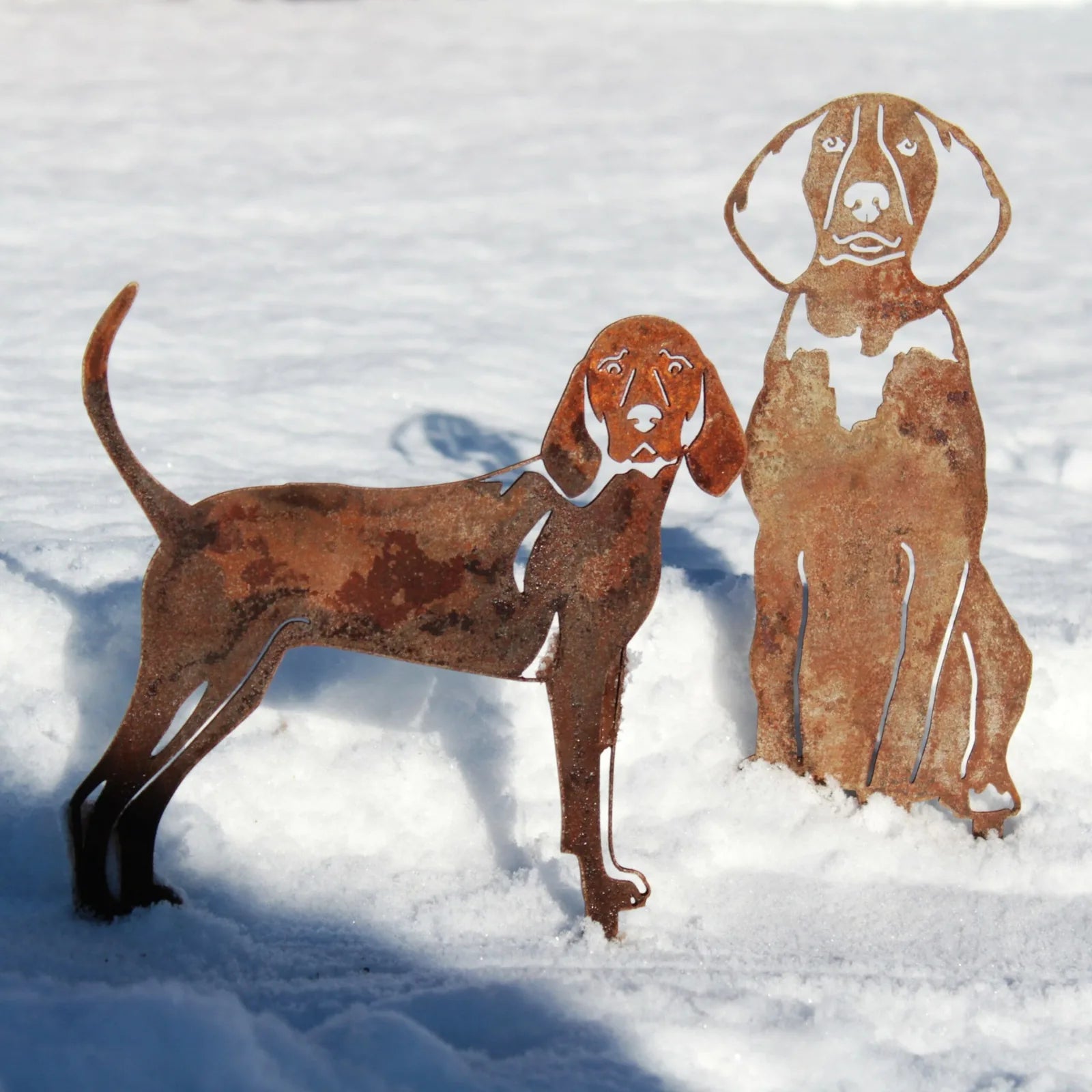 Rusty Redbone Coonhound metal silhouettes in snow, showcasing intricate design and handmade Corten steel material.