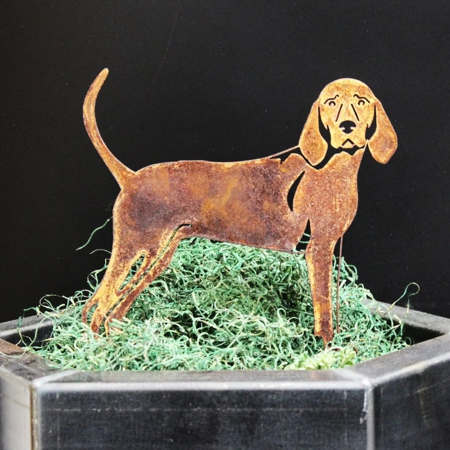 Rusty Redbone Coonhound metal silhouette standing atop green moss in a black planter, adding charm to home decor.