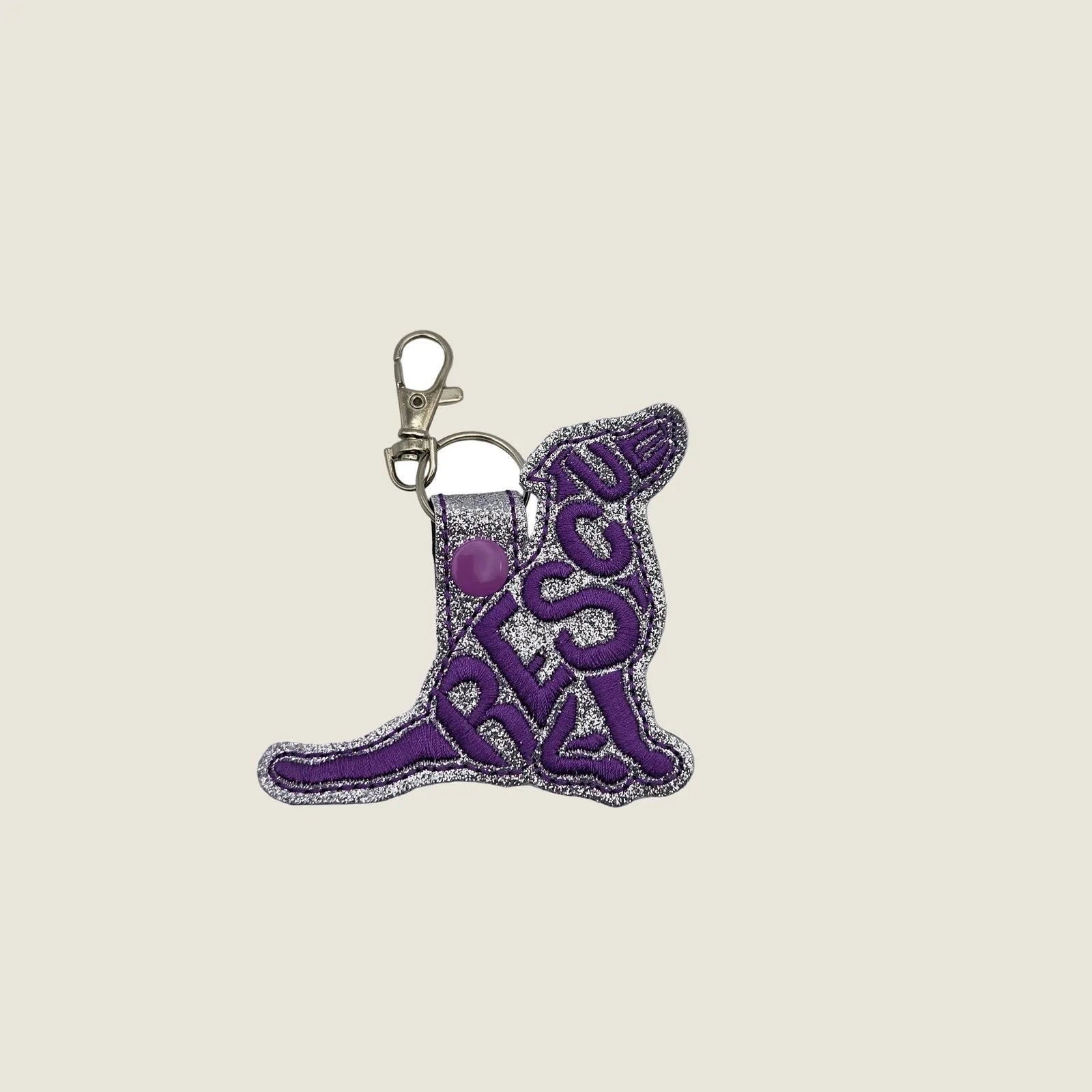 Embroidered purple "RESCUE" keychain tab with silver glitter backing and a metal lobster clasp. Great for dog lovers.