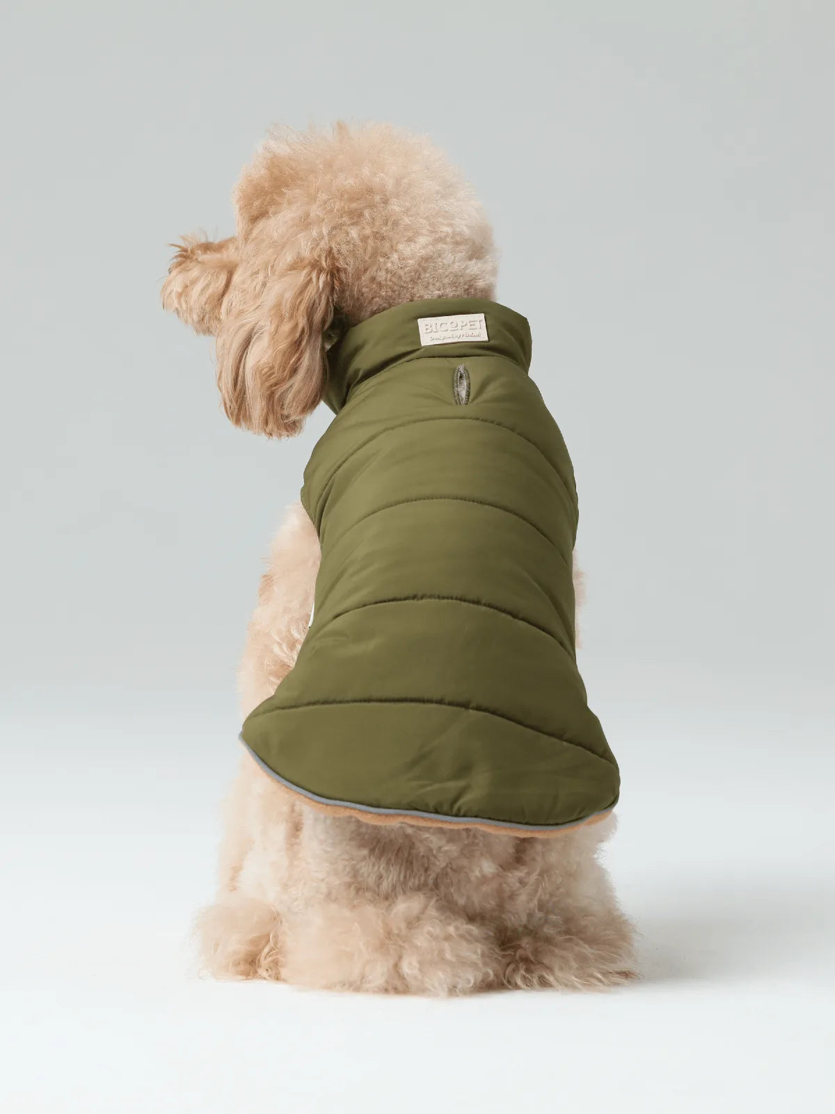 Reversible green dog vest jacket with polar fleece lining, featuring adjustable collar and leash hole for secure fit.