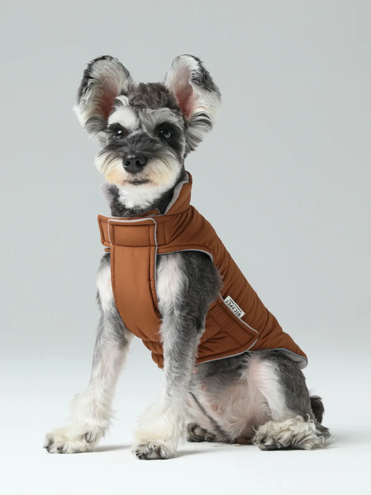 Reversible orange and grey dog vest jacket with adjustable fit and fleece lining, ideal for cold weather protection.