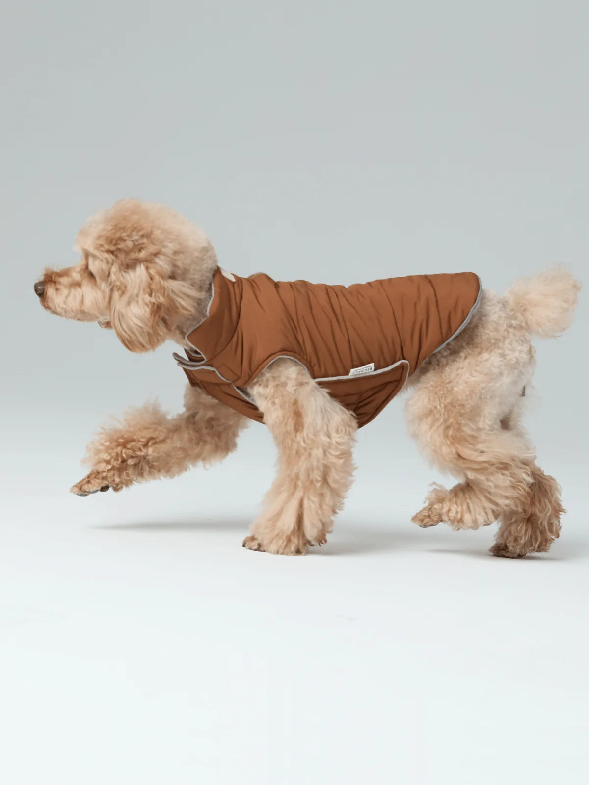 Reversible dog vest in orange and gray, featuring a snug fit and cozy fleece lining, perfect for cold weather outings.