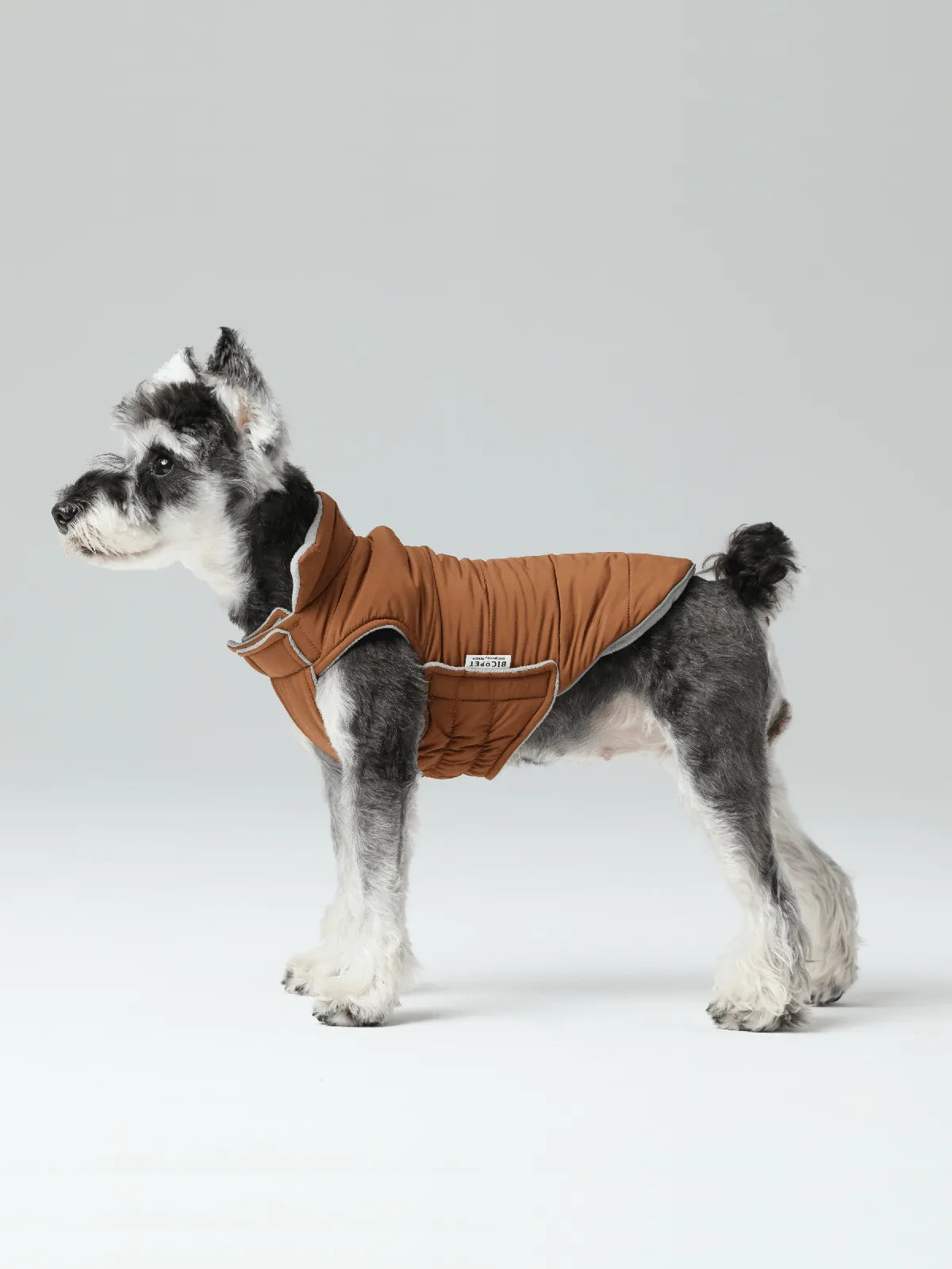 Reversible orange and grey vest jacket on a dog, featuring a windproof design with a snug fit and polar fleece lining.