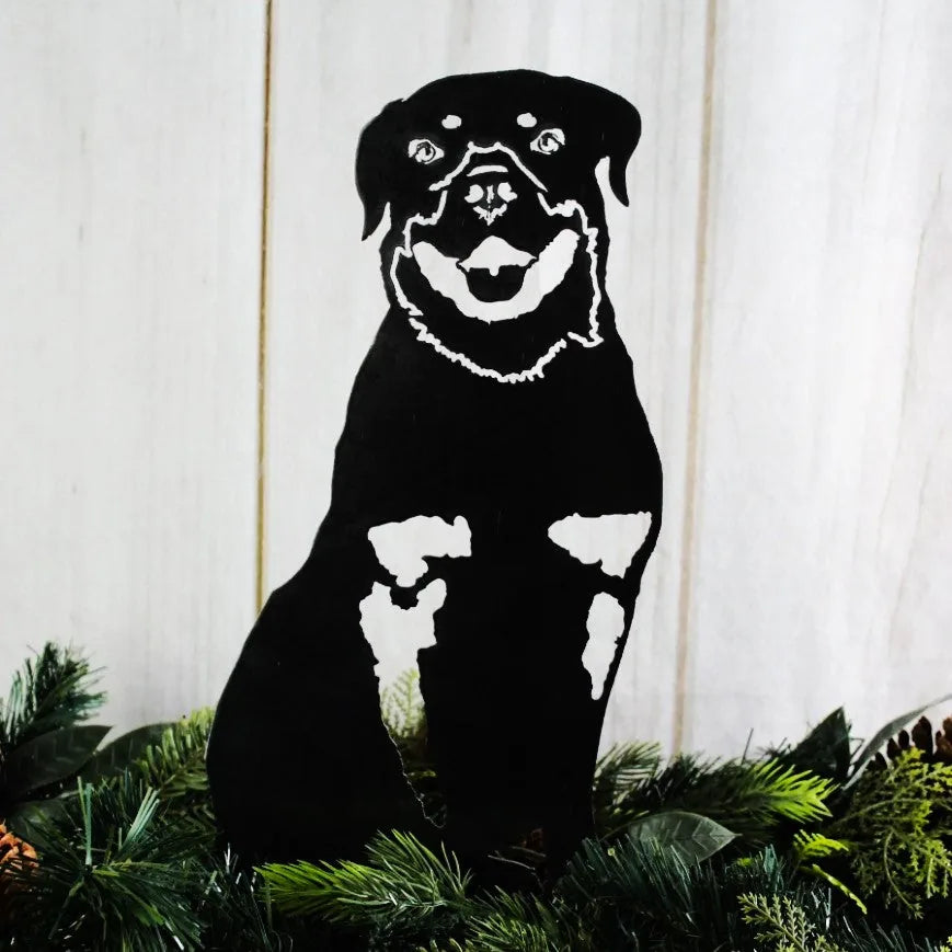 Black metal silhouette of a Rottweiler sitting among greenery, designed for outdoor dog decor from My Metal Rescue.