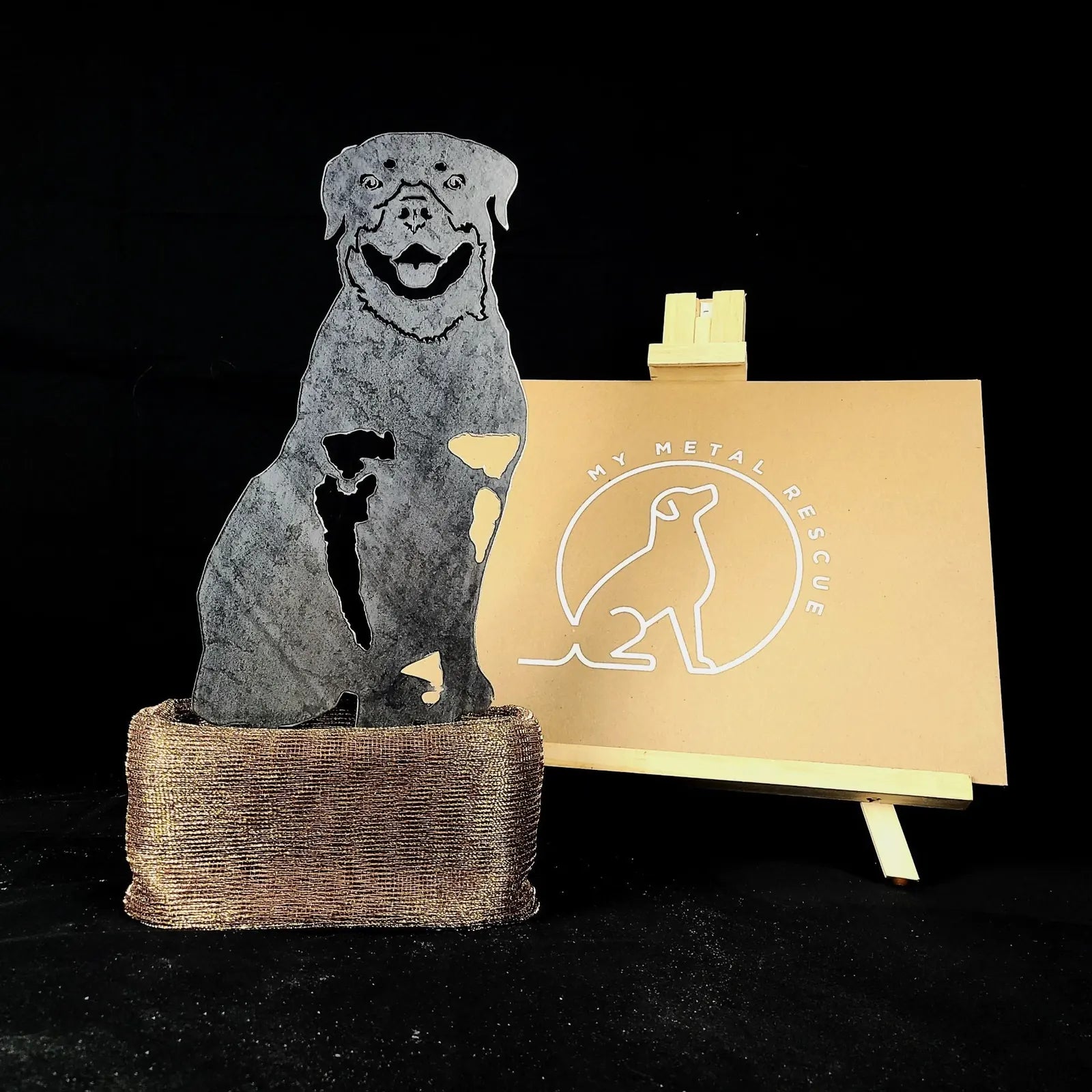 Rottweiler metal silhouette in black Corten steel, showcasing detailed cutouts, on a rustic base. Ideal outdoor dog decor.
