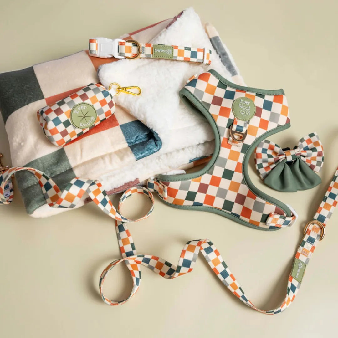 Cozy Sage & Cider Dog Blanket with cream sherpa texture and a checkerboard design in green, orange, and beige hues.