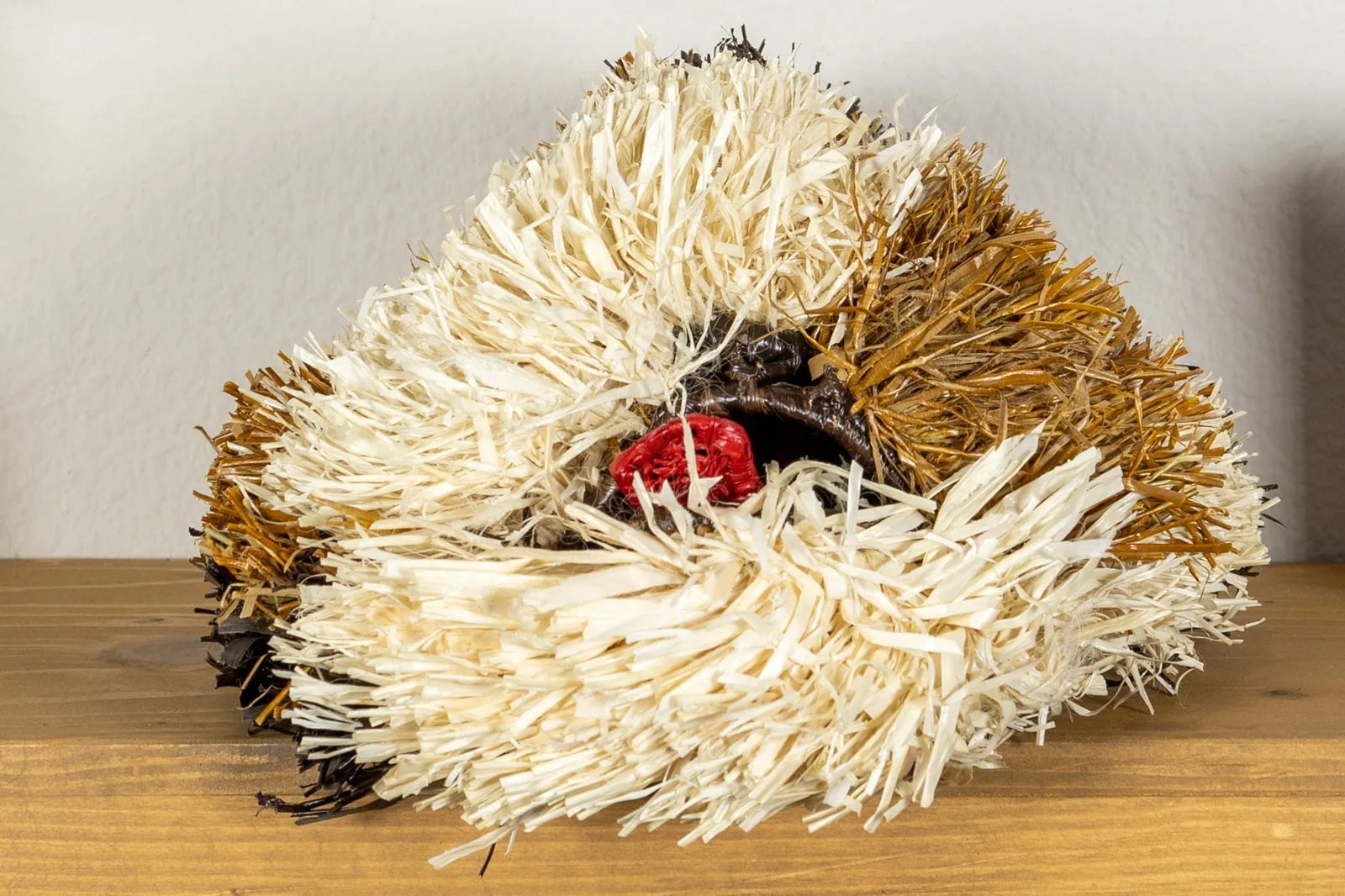 Handwoven Saint Bernard dog mask featuring vibrant white, brown, and red fibers, crafted by Indigenous artisans in Panama.