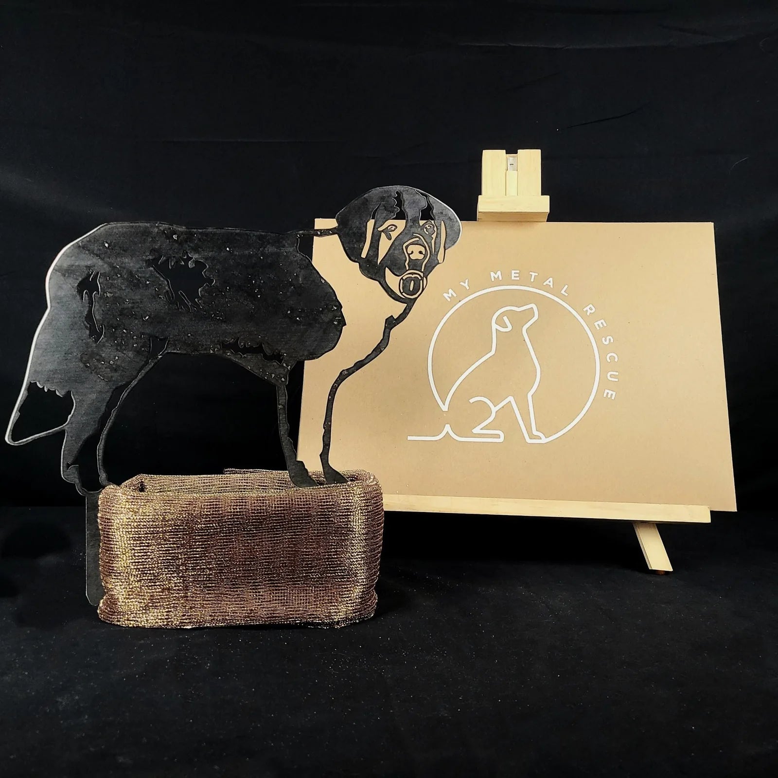 Black metal silhouette of a Saint Bernard dog, displayed on a textured base, alongside branding for My Metal Rescue.