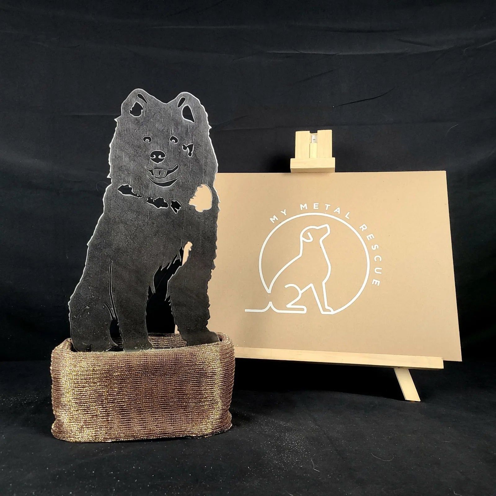 Samoyed metal silhouette art in black, displayed on a textured base with a gold-colored accent.