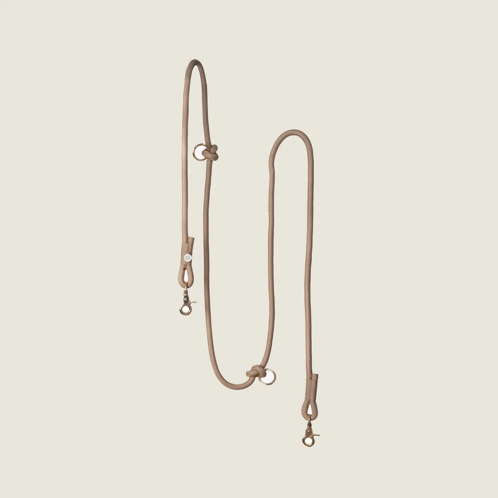 Braided hands-free dog leash in a neutral sand color, featuring clips and adjustable design for comfortable use.