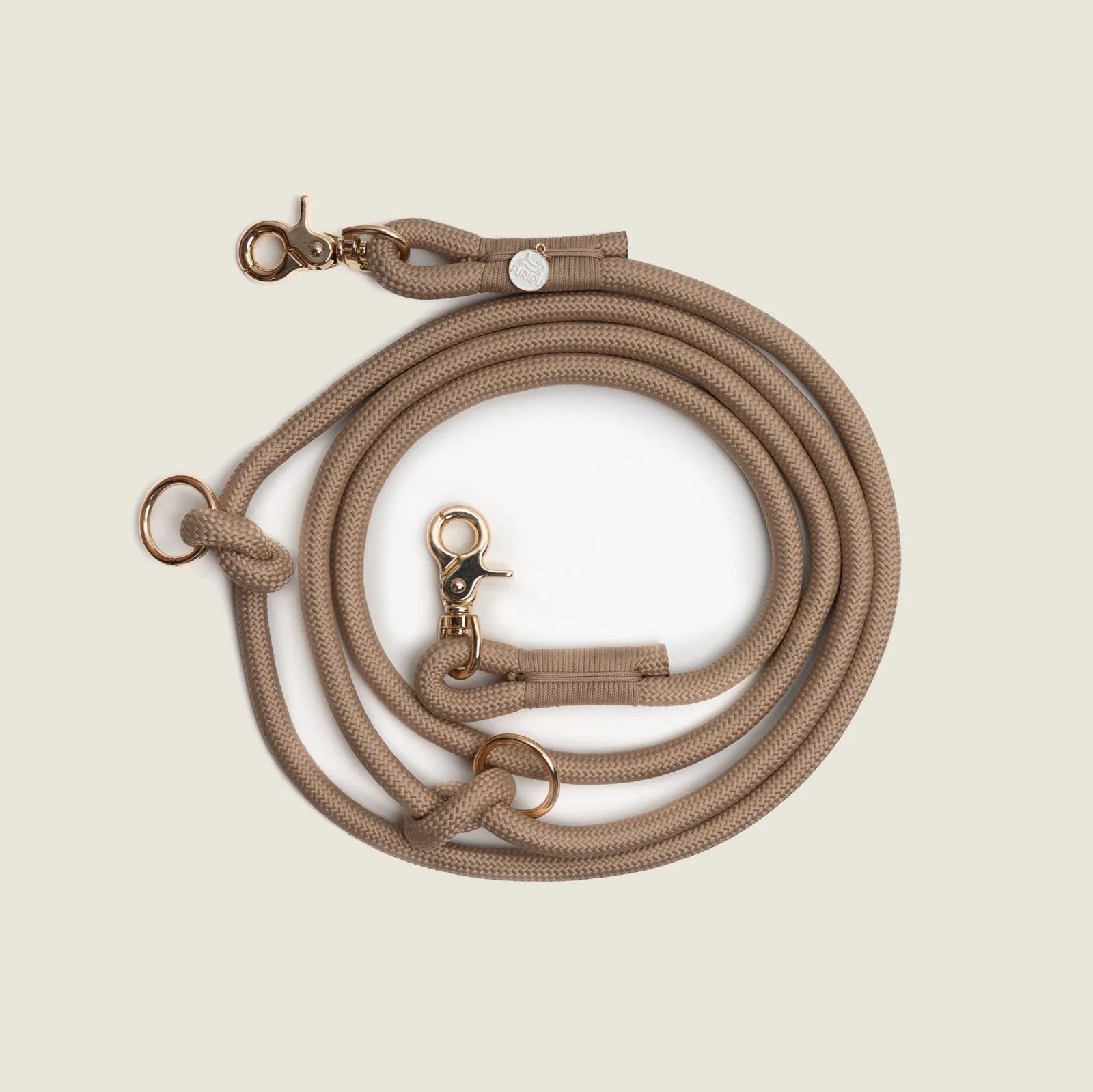 Hands-free braided leash in sandy beige with gold-tone clips, designed for comfort during walks and outdoor activities.