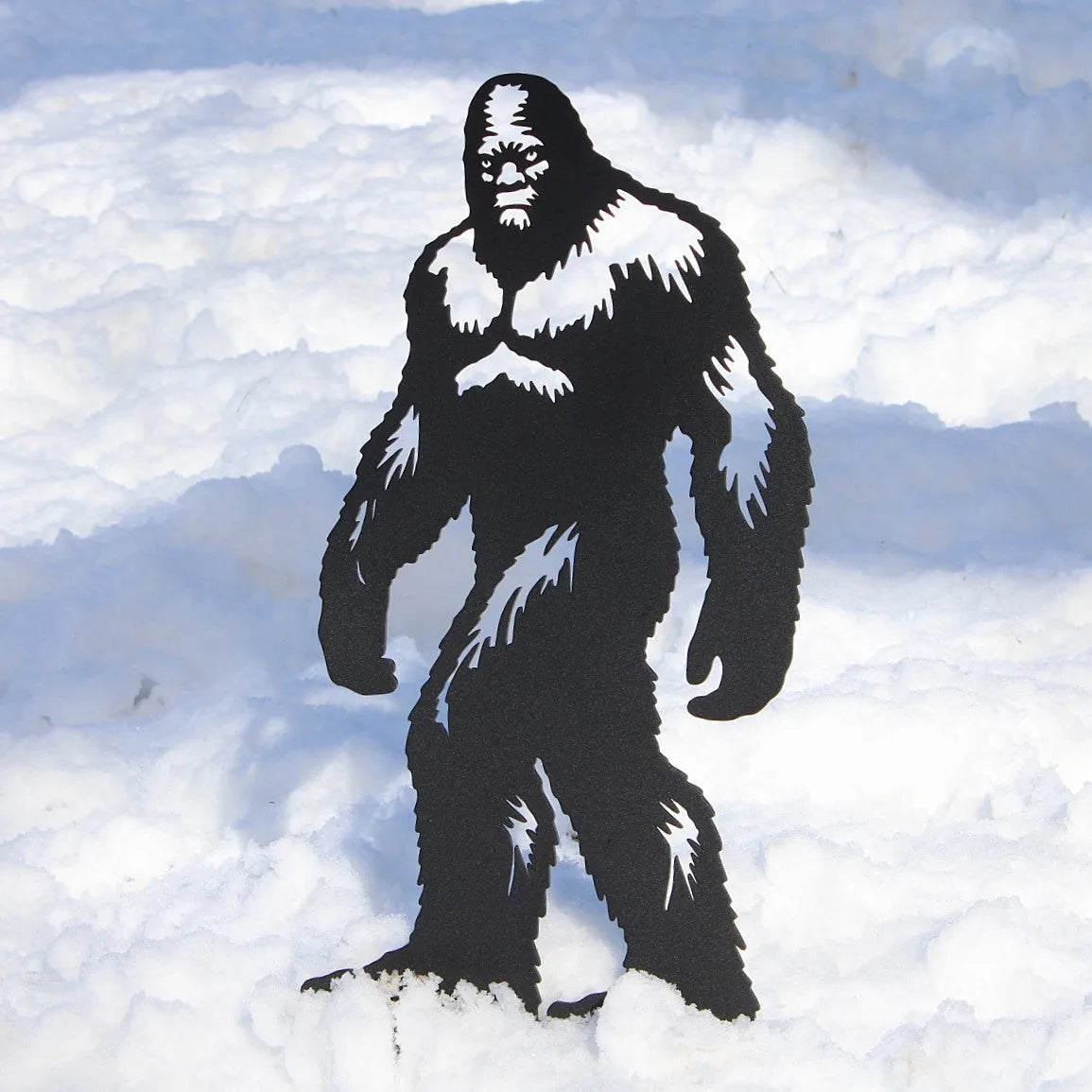 Black Sasquatch metal silhouette standing in snow, showcasing detailed features and sturdy design for outdoor decor.