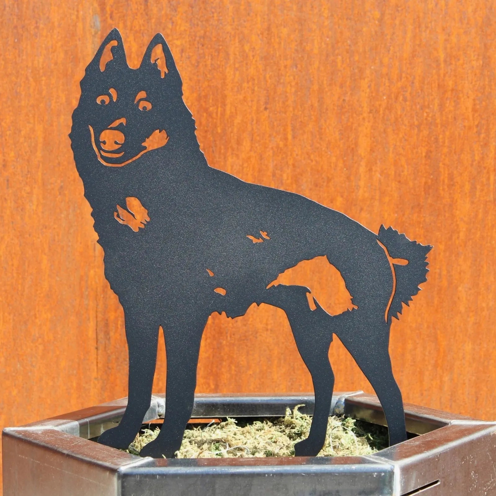 Black metal silhouette of a Schipperke dog standing in a planter, crafted from sturdy weather-resistant material.