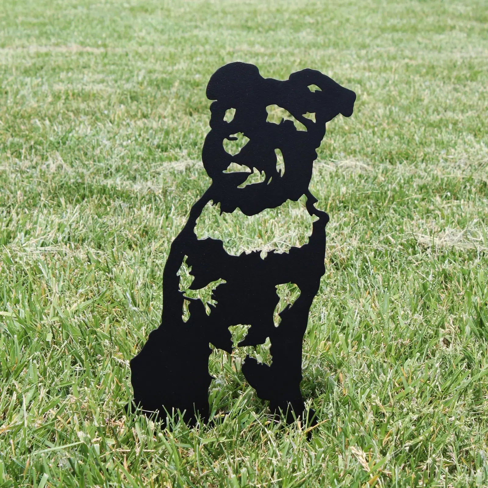 Black metal silhouette of a Schnauzer standing in grass, showcasing intricate cut-out details for outdoor decor.