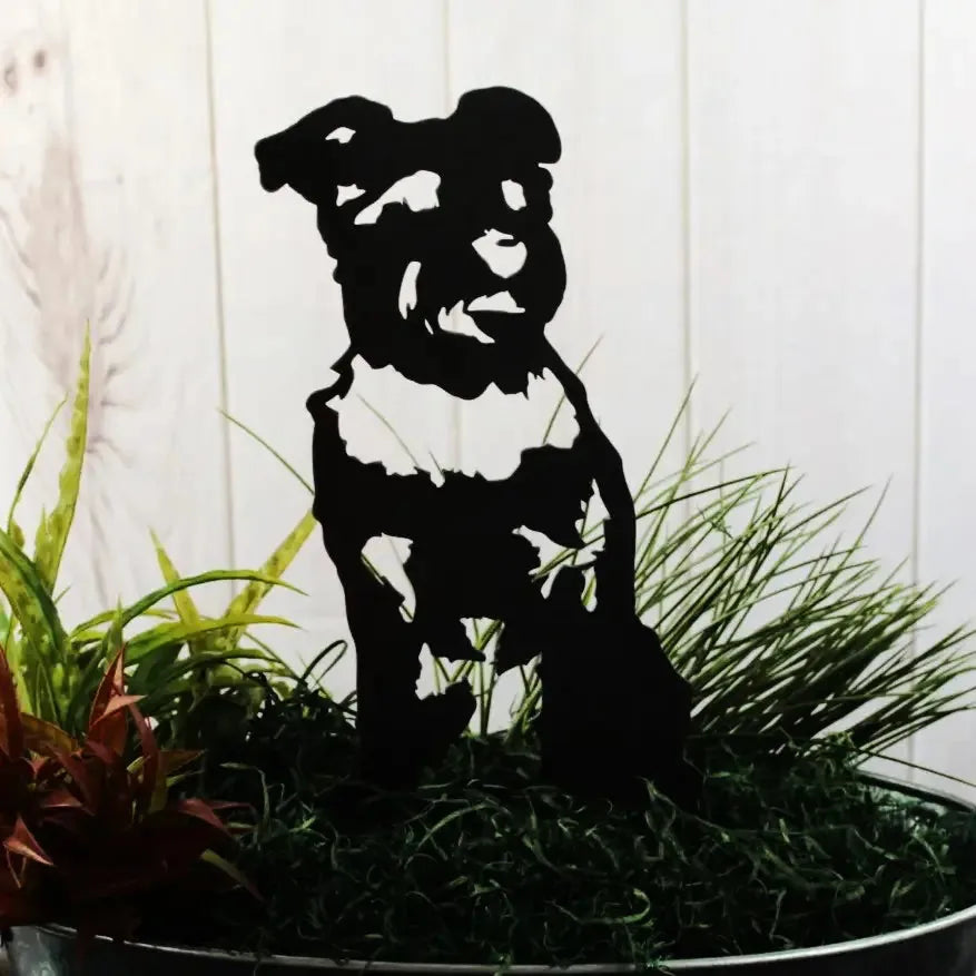 Black Schnauzer metal silhouette sculpture displayed among greenery, perfect for outdoor decor.