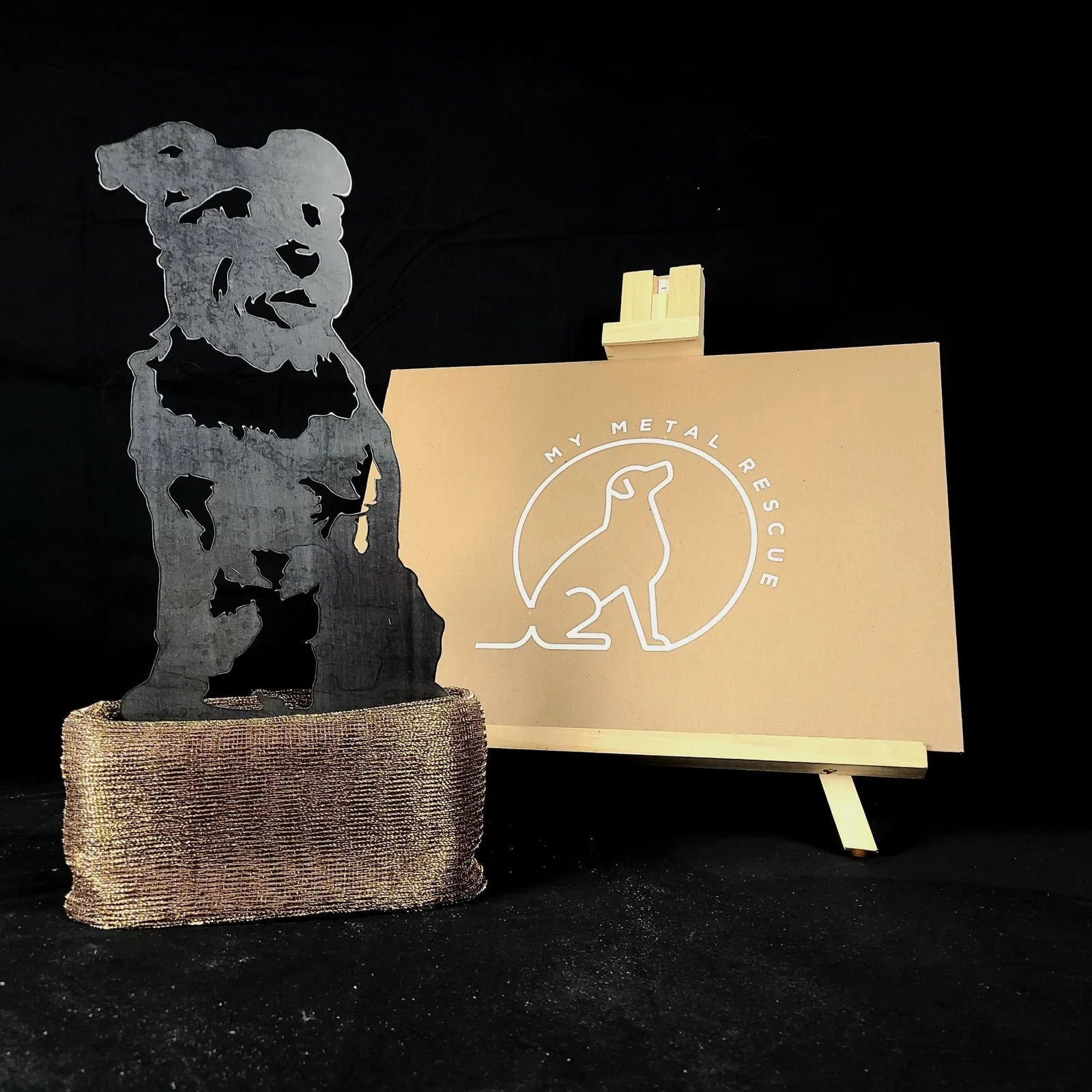 Schnauzer metal silhouette in a matte black finish, displayed with a branded sign, set against a dark background.