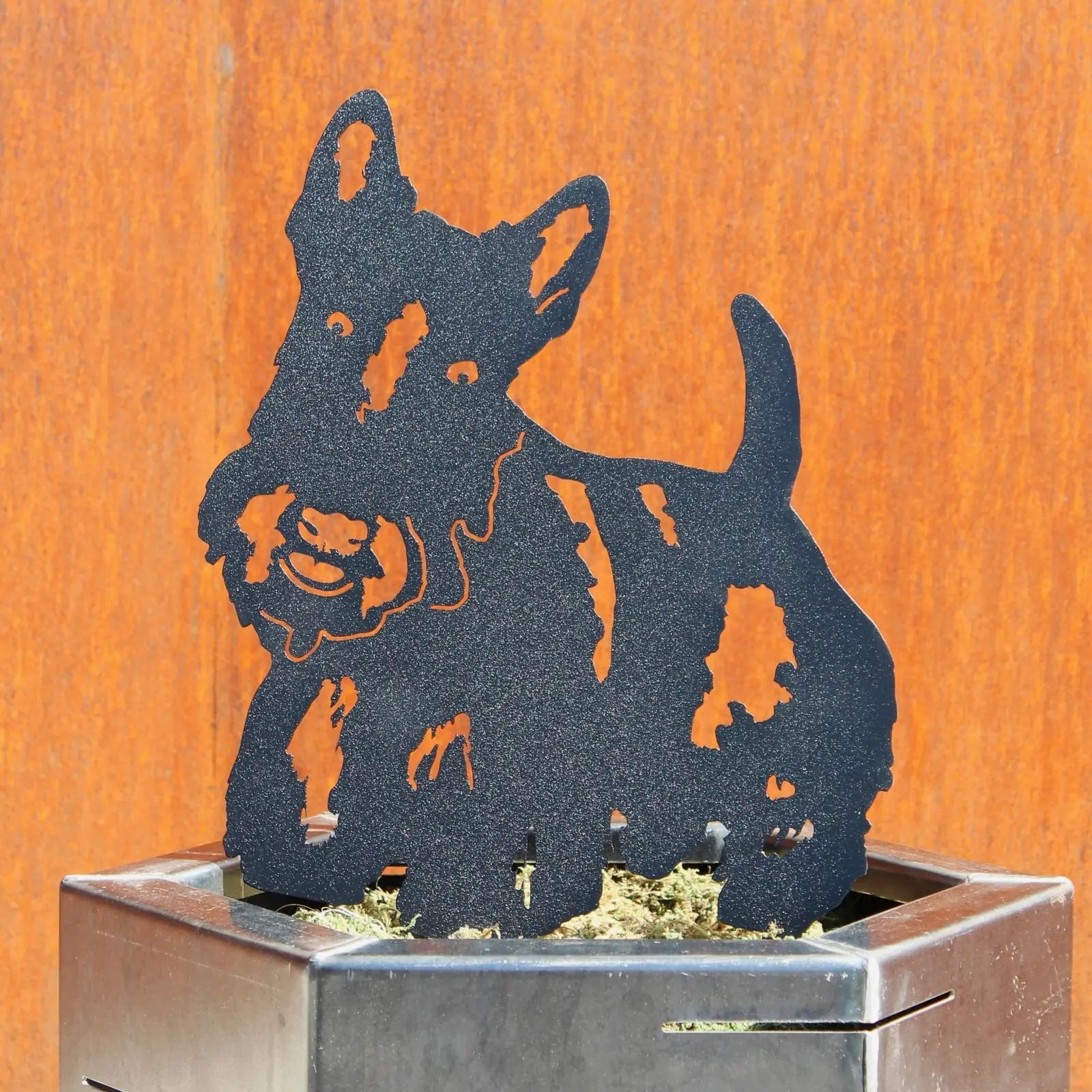 Scottish Terrier metal silhouette in matte black, perched atop a planter, showcasing detailed craftsmanship.
