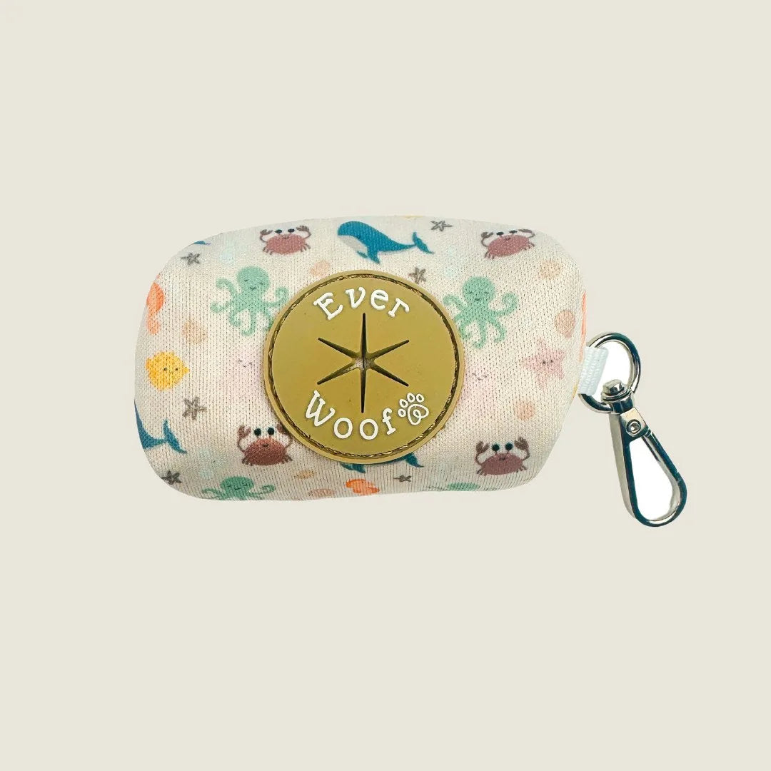 Neoprene waste bag holder featuring a colorful ocean-themed design with crabs, octopuses, and whales, attached by a metal...
